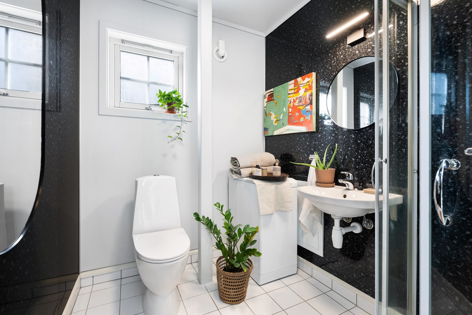 Badet er fra 2004 og har flislagt gulv med gulvvarme og baderomspanel på vegg. Opplegg for vaskemaskin. Galleribilde