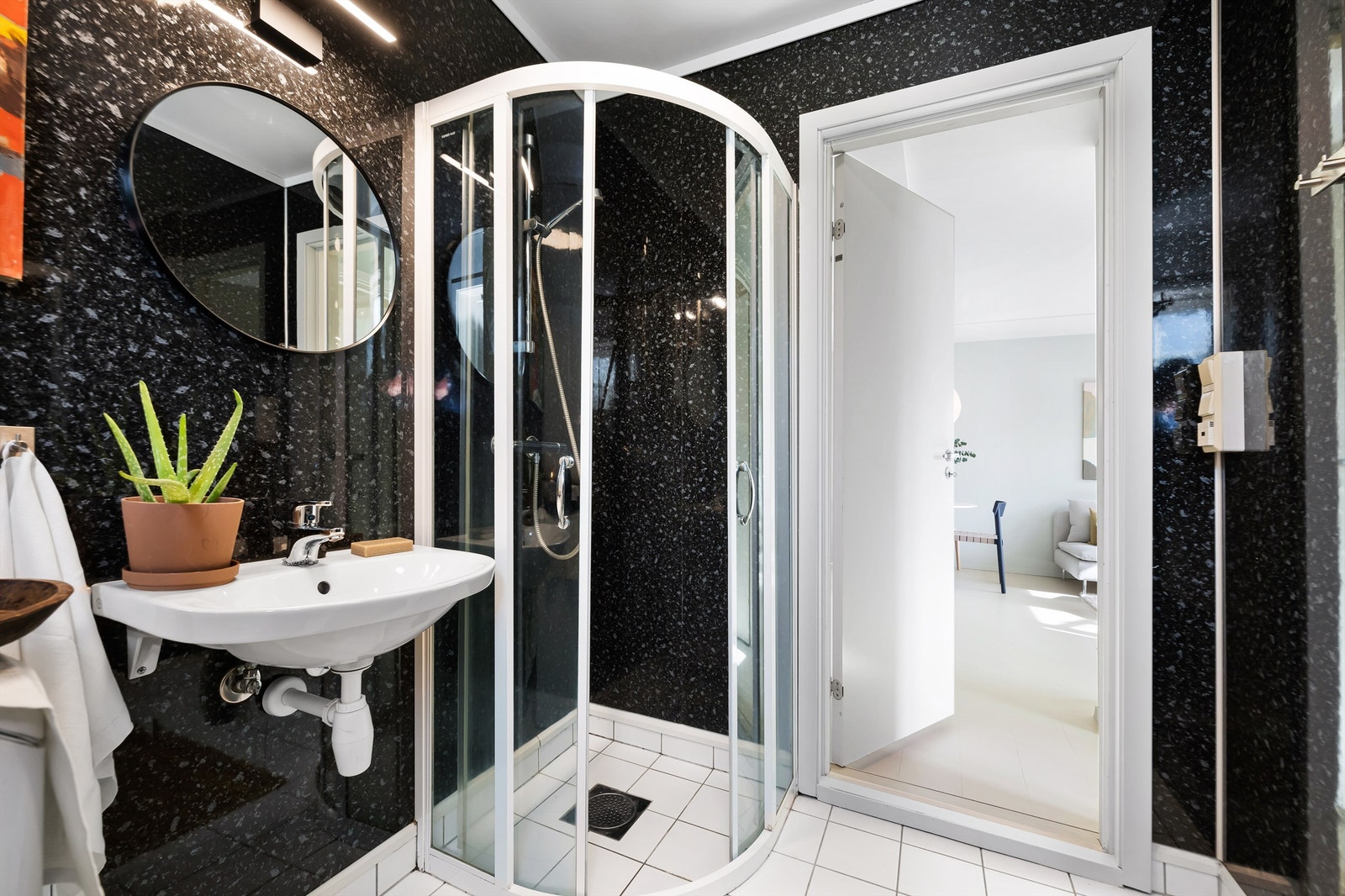 Dusjhjørne med dører, vegghengt servant og gulvstående toalett. Badet har mekanisk avtrekksvifte. Galleribilde
