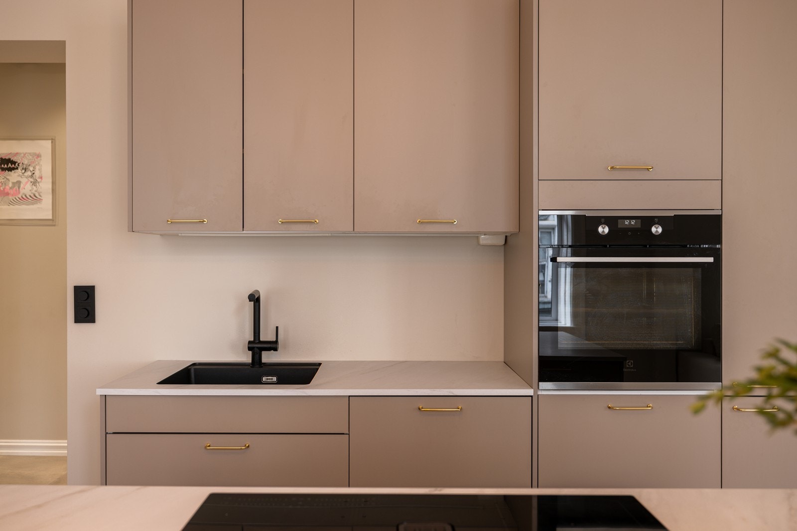 Kjøkkeninnredning med laminert benkeplate, nedfelt oppvaskkum og ettgreps blandebatteri Galleribilde