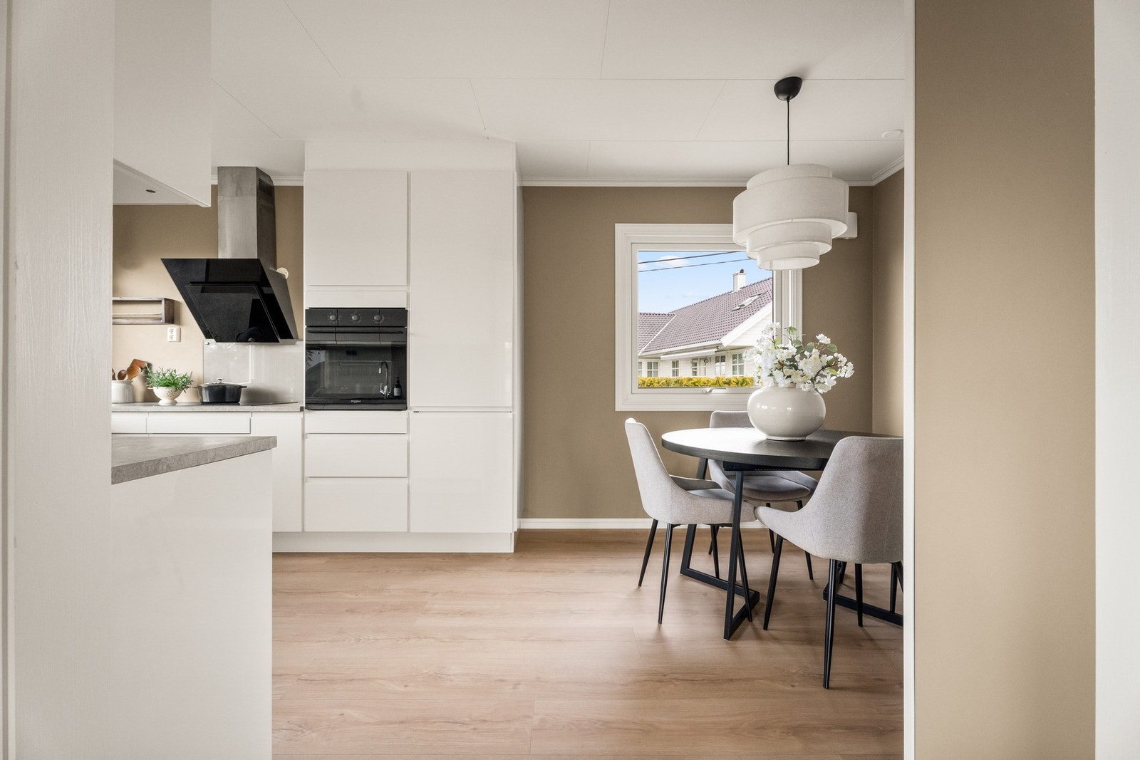 Det ble åpnet opp mellom rommene i 2025, og samtidig fikk kjøkkenet nye vinduer, nytt listverk, nye veggplater og nytt 1-stavs laminatgulv - det samme som i stuen. Galleribilde