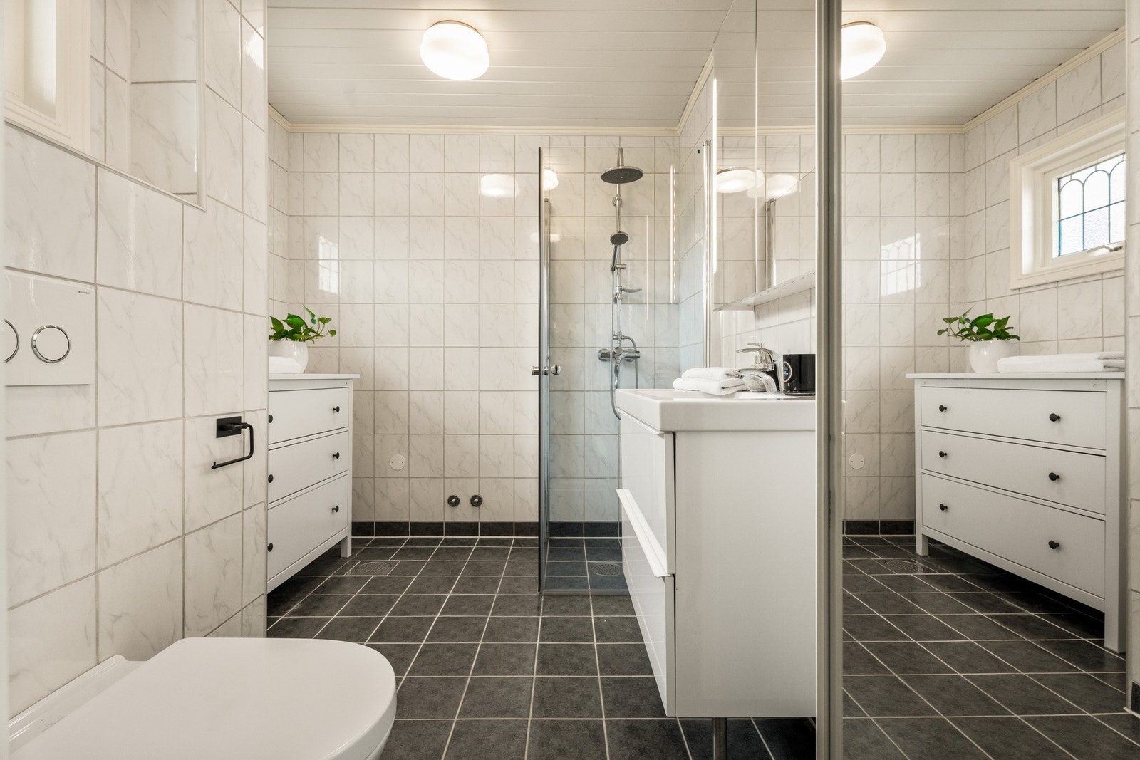 Badet ble pusset opp i 2014, innredet med lyse veggfliser og mørke gulvfliser for en fin kontrast. Galleribilde