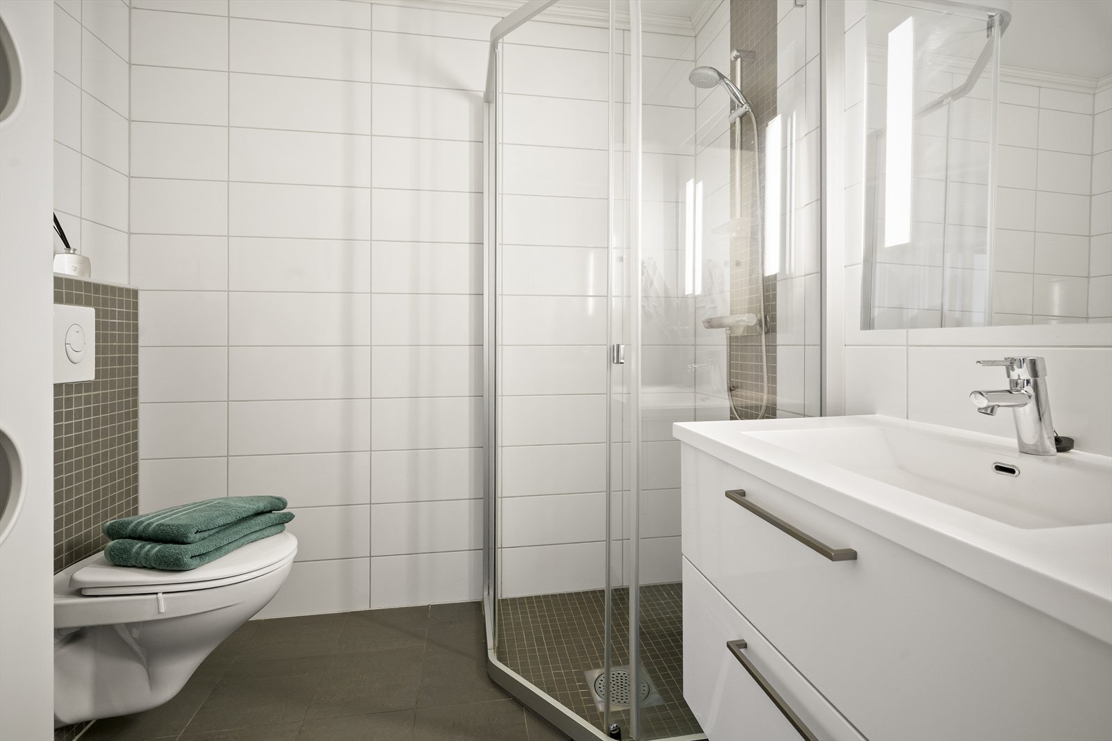 Rommet er innredet med vegghengt toalett, servantinnredning med oppbevaring og opplegg for vaskemaskin. Galleribilde