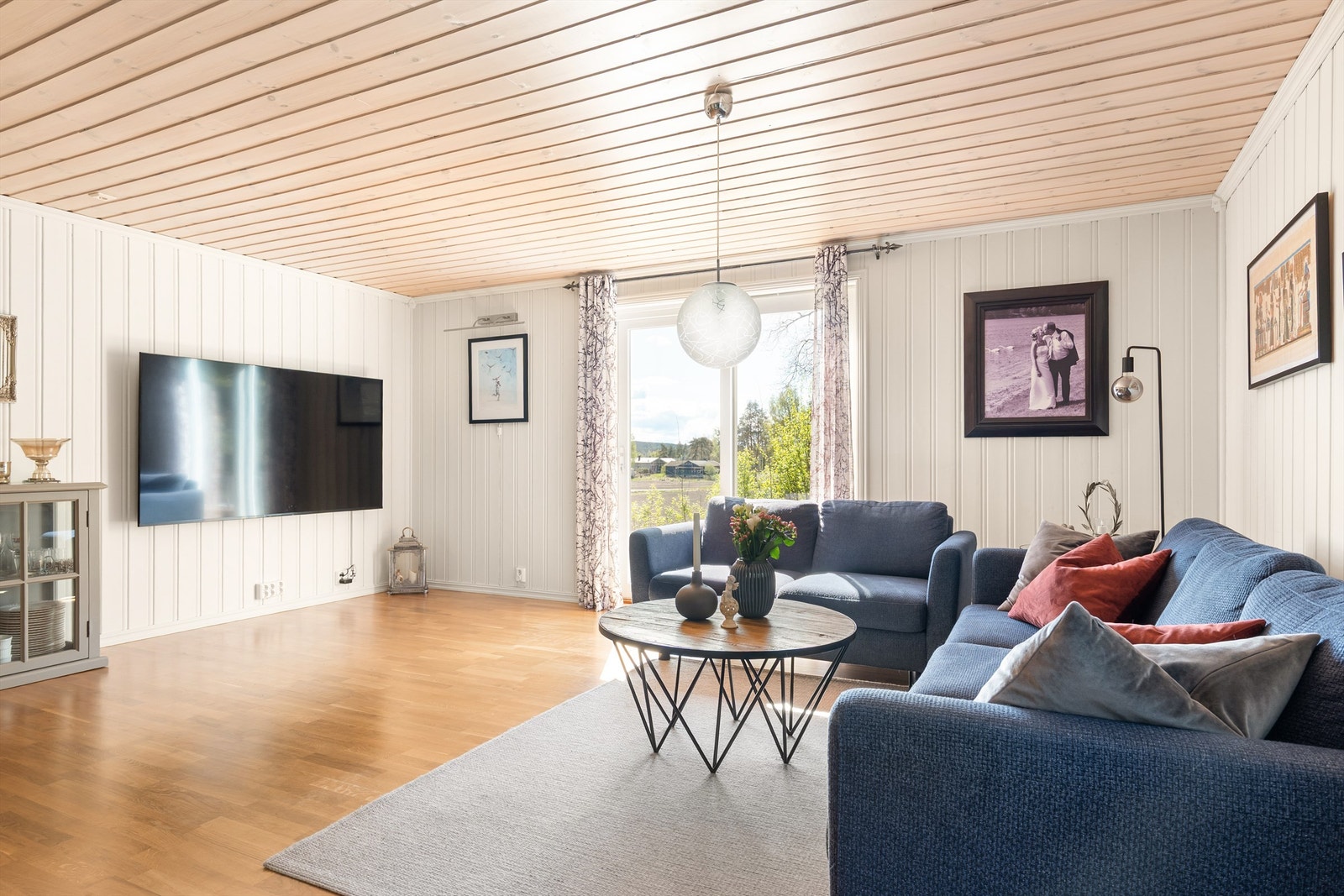 Skyve-/hevedør mot sør slipper solen inn til stuen og gir utsikt til det bølgende åkerlandskapet. Galleribilde