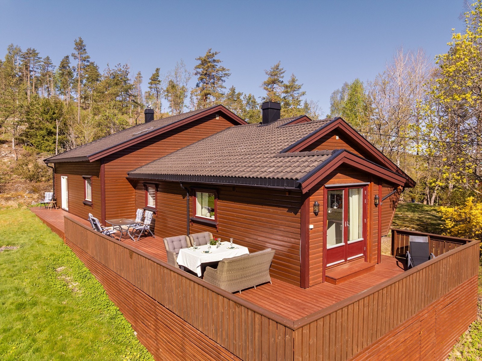 Stor terrasse ble oppført rundt boligens øst fra 2001- og sørside som omfatter tilbygget så nylig som i 2020. Beis i samme nyanse som kledningen skaper et meget helhetlig uttrykk. Galleribilde