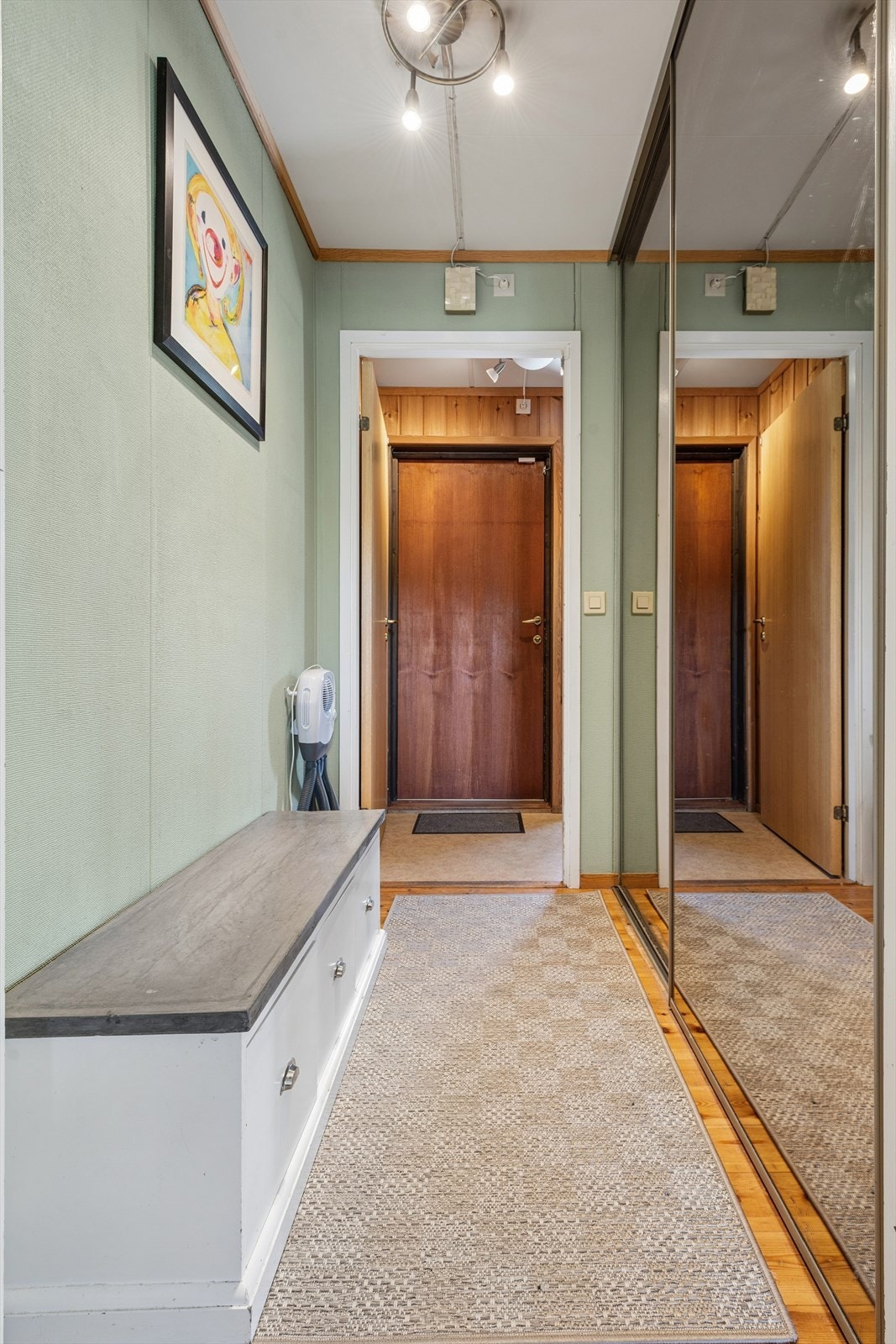 Videre inn er entreen med plass til å henge fra seg yttertøy i skyvedørsgarderobe med speilfronter for rikelig med oppbevaring og bidrar til romfølelsen. Galleribilde