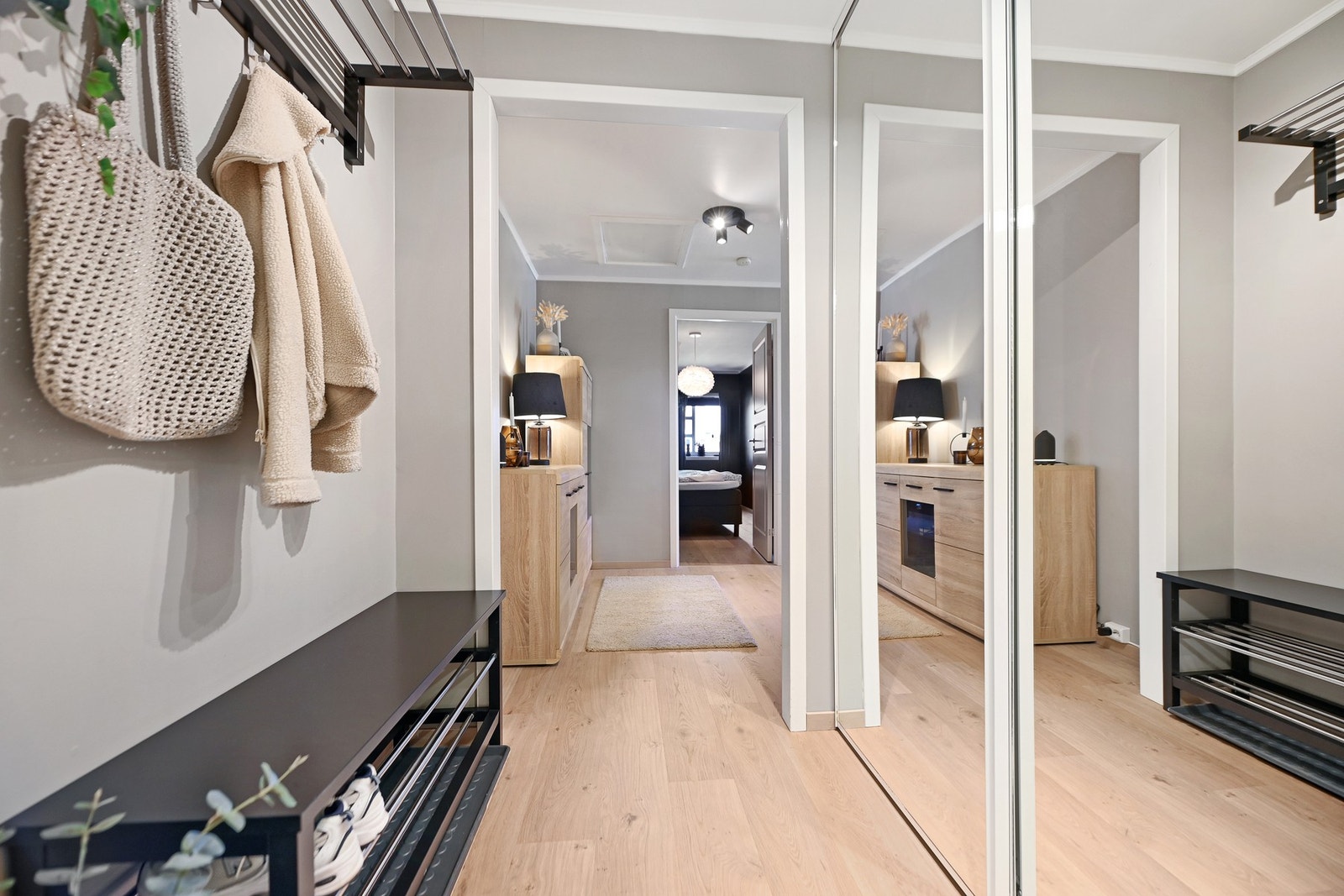 Lyst og innbydende inngangsparti med speilskyvedørsgarderobe og praktisk oppbevaringsløsning. Galleribilde