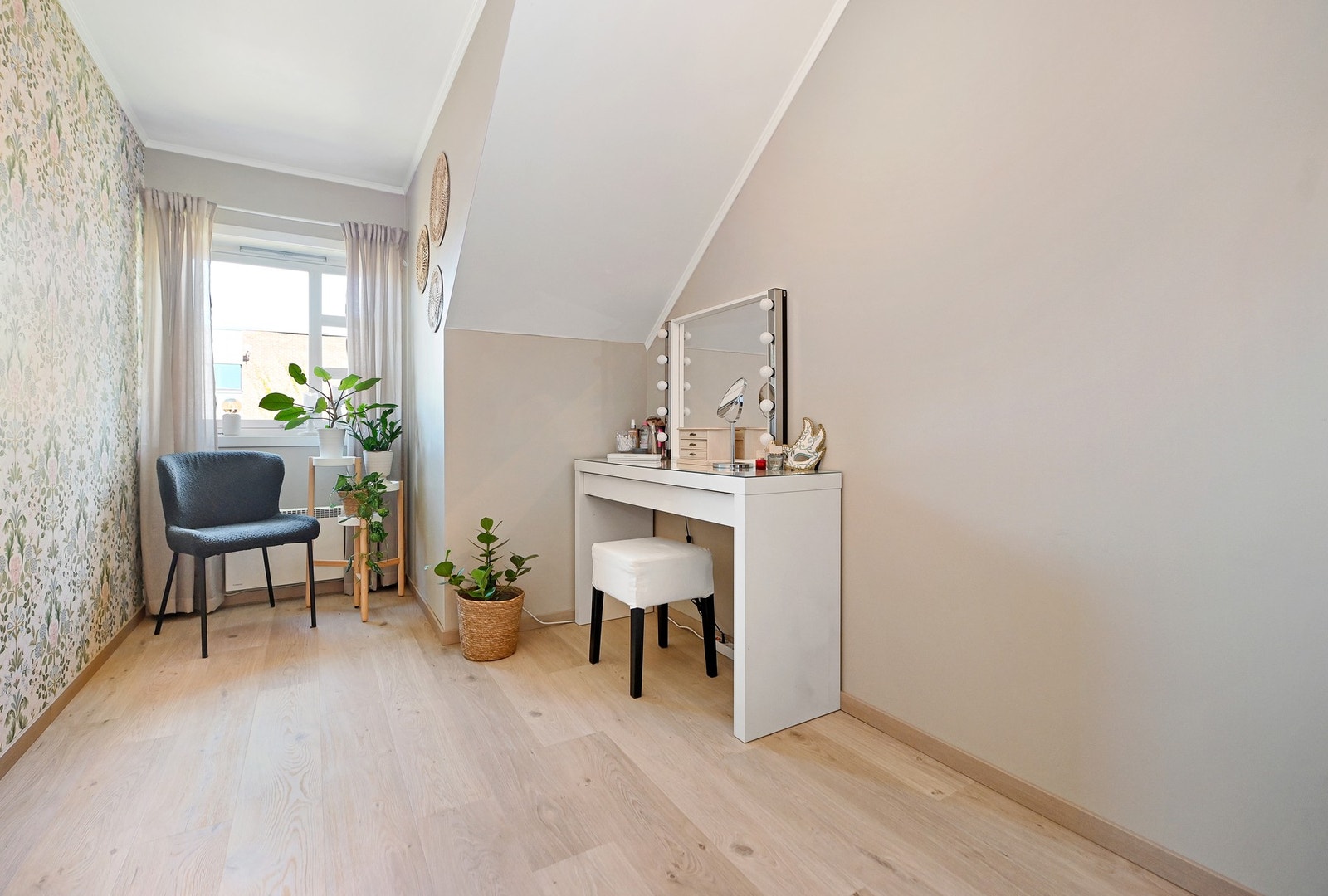 Lyst rom med skråtak og vindu som slipper inn naturlig lys. Galleribilde