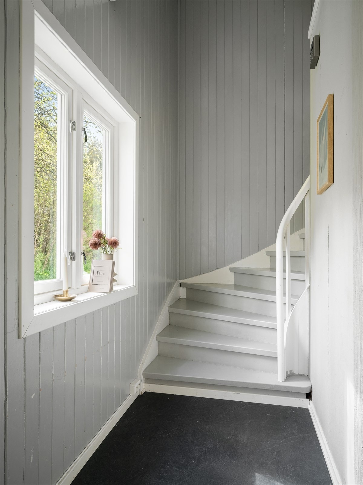 Malt tretrapp med panelvegger leder opp til andre etasje. Galleribilde