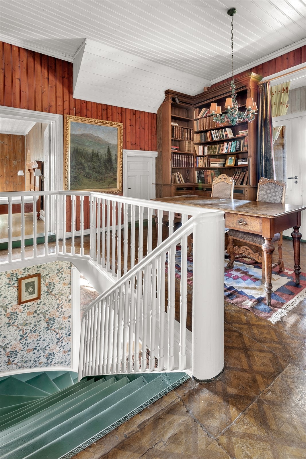 Trapperommet har et nydelig, originalt gulv og plassbygde bokhyller. Galleribilde