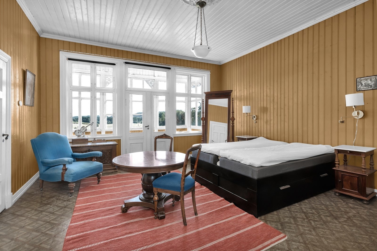 Hovedsoverommet forlenges av en innglasset veranda med storslått utsikt over jordene. Dagslyset flommer inn via de store vinduene og tilfører en lett og lys atmosfære. Galleribilde