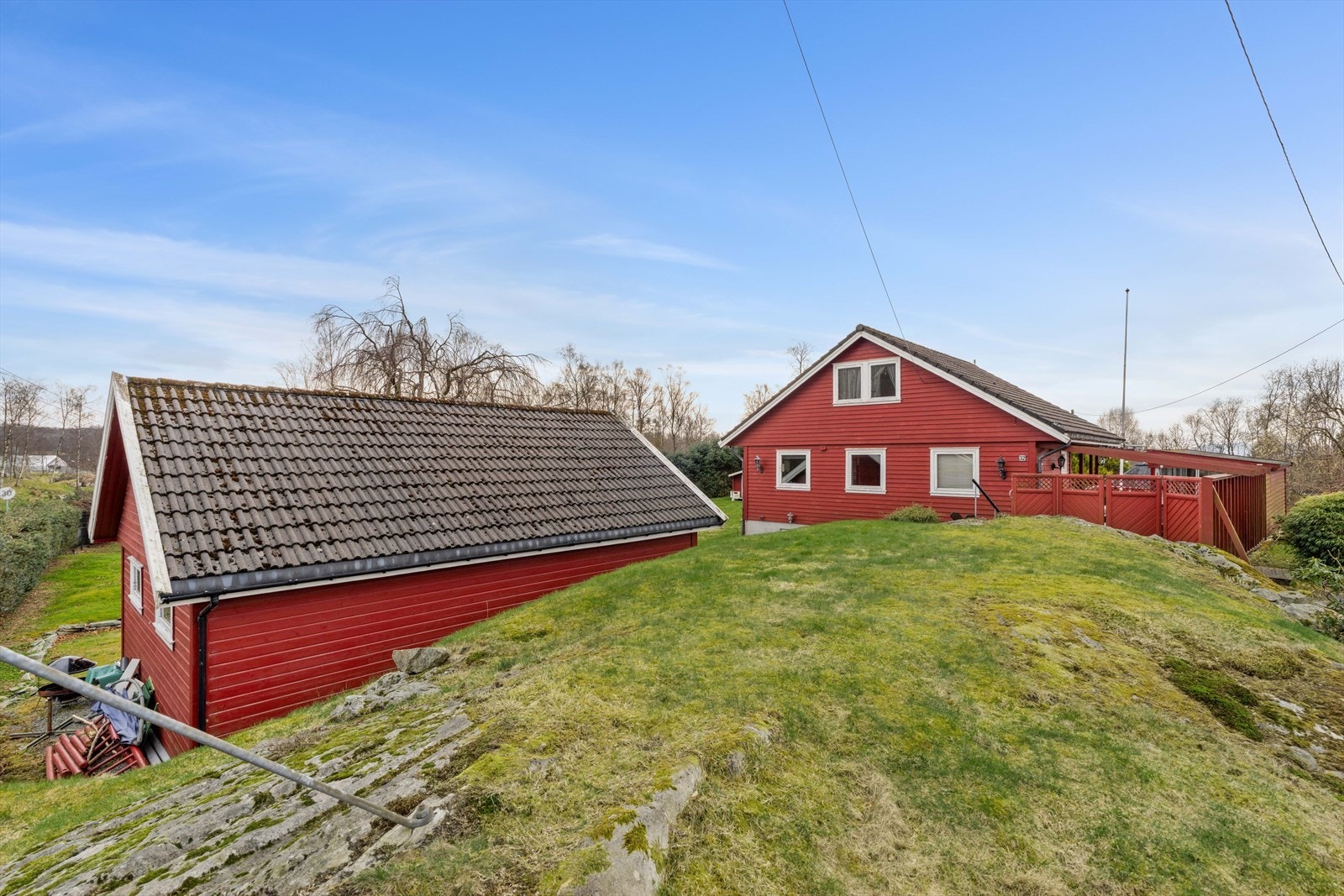 Hytta og garasjen sett fra oversiden av tomten. Galleribilde