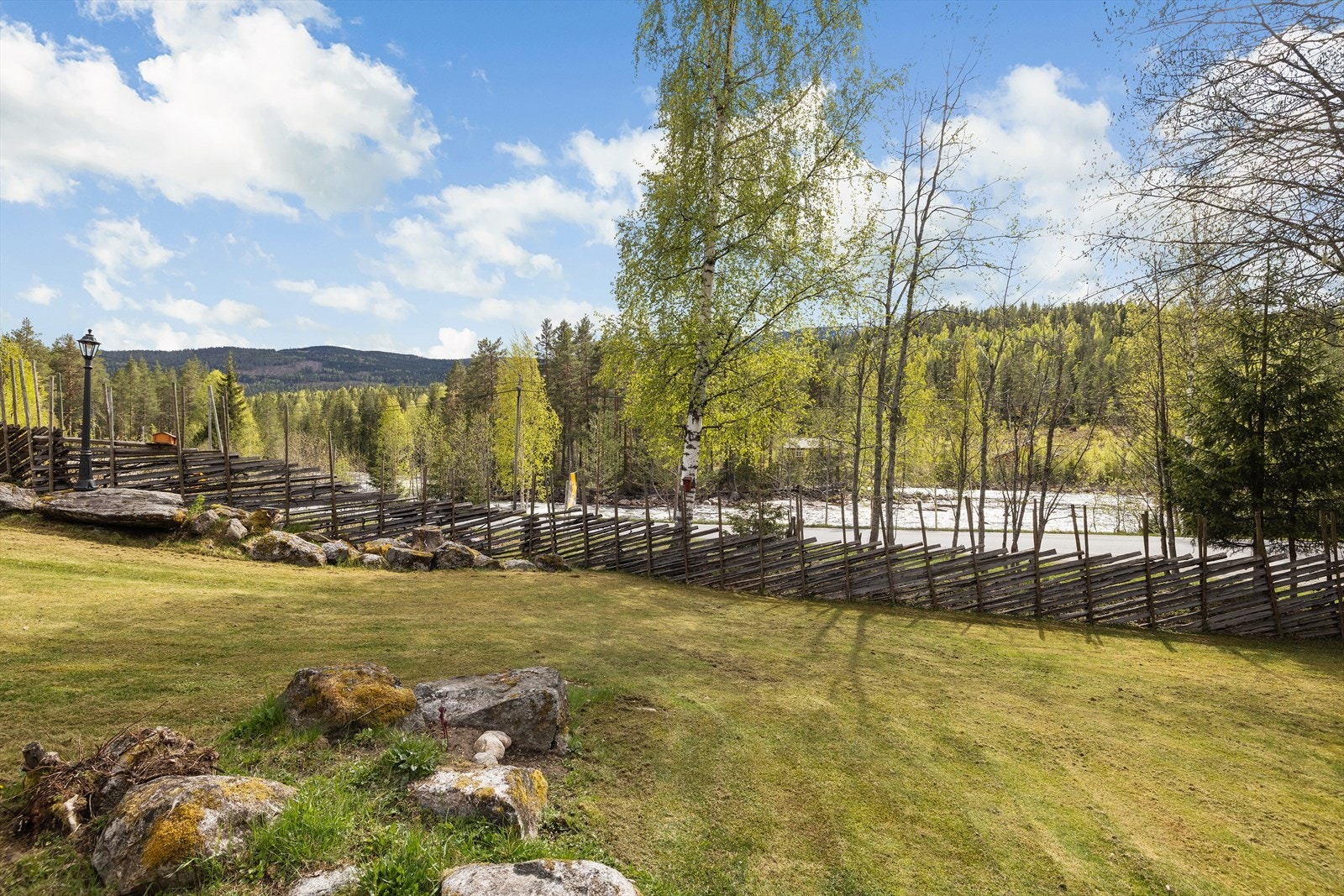 Utsikt fra tomten mot elven og skigarden som rammer inn eiendommen. Galleribilde