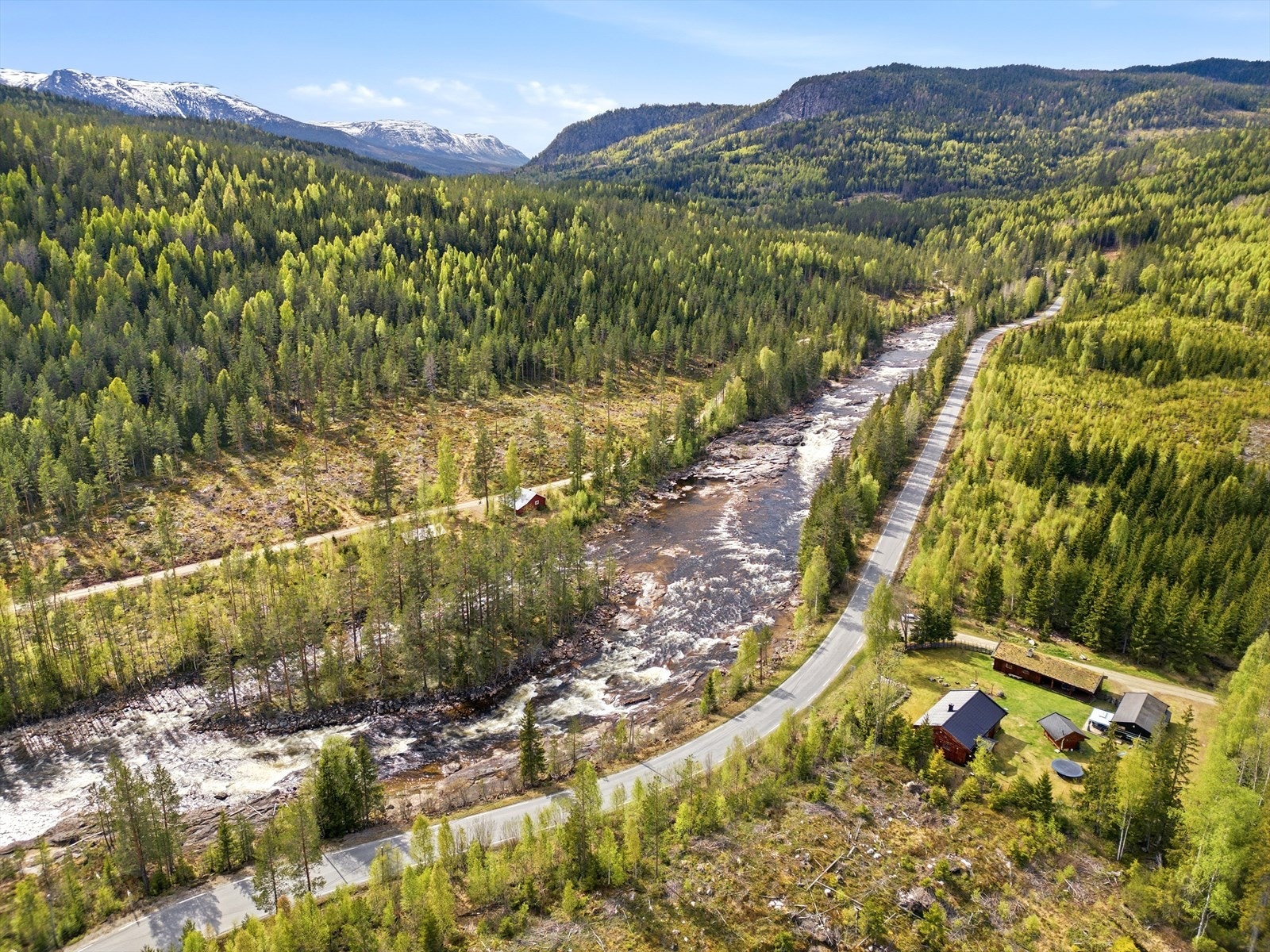 Utsikt over dalføret med elven og fjellene i horisonten. Galleribilde
