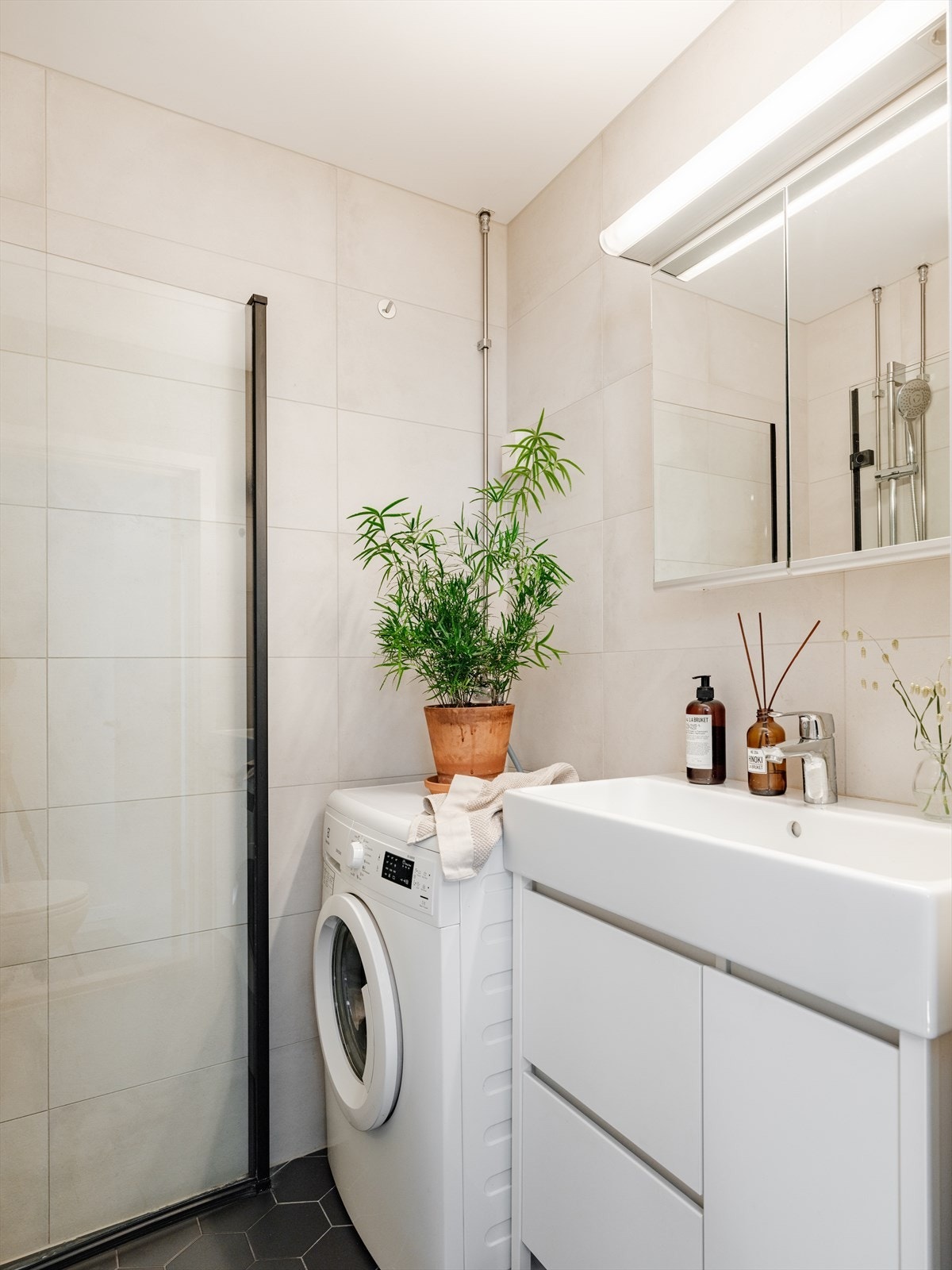 Badet består av benkeskap, dusj med innfellbare dører, servant, veggfestet klosett og vaskemaskin som medfølger. Galleribilde