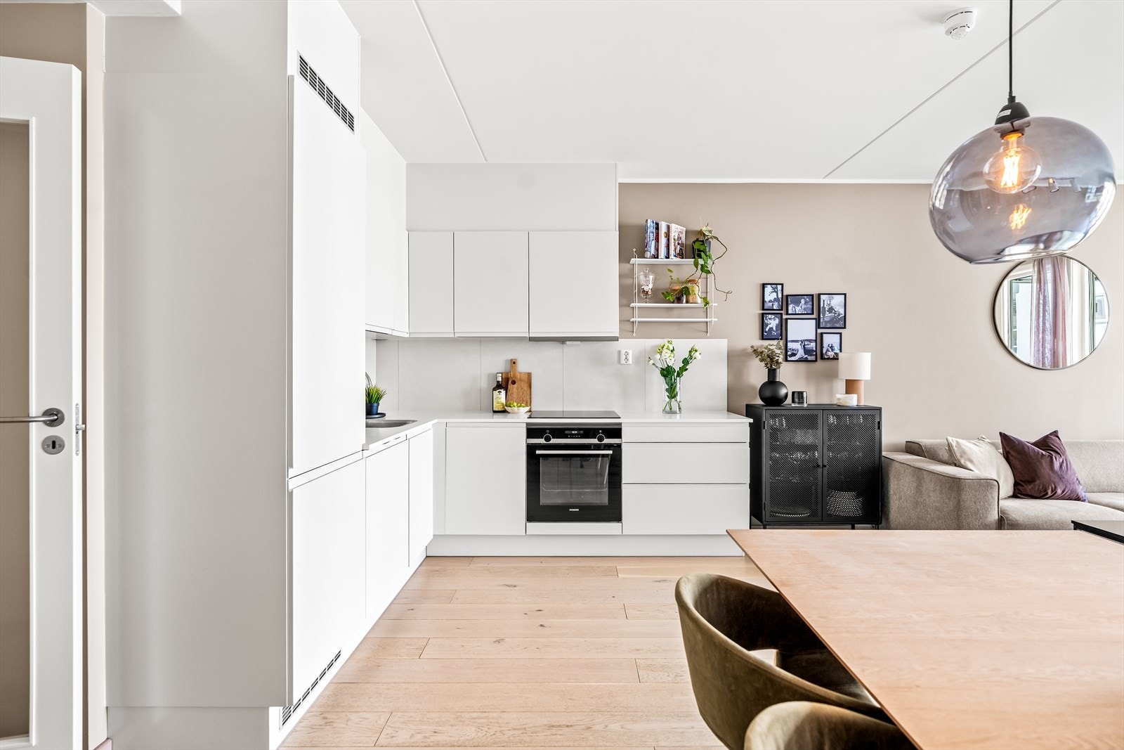 Skapene har glatte hvite fronter, og det er satt inn benkeplate i laminat. Galleribilde