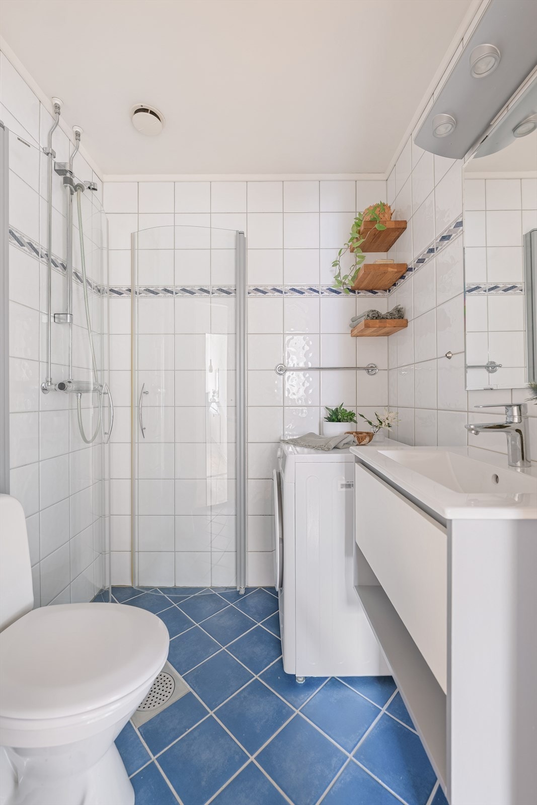 Bad modernisert i regi av borettslaget i 2001, med fliser på gulv og vegger, standard innredning, integrert himlingsbelysning, dusjhjørne og opplegg for vaskemaskin. Galleribilde