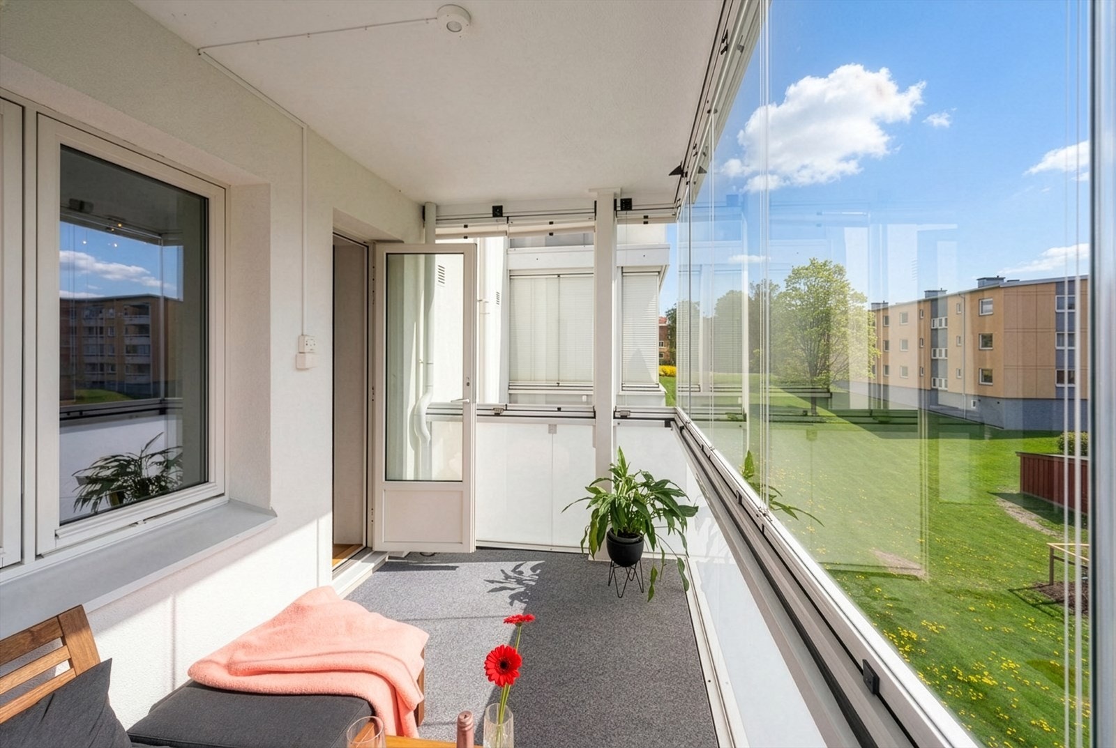 Utgang fra stuen til en stor innglasset balkong på 7 m² med meget gode solforhold. Balkongen oppleves som en forlengelse av stuen på sommerhalvåret med hyggelig utsyn mot felles grøntarealer. Galleribilde