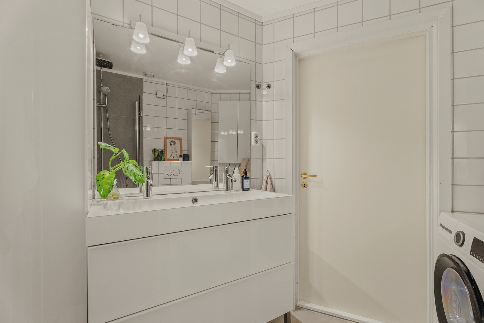 Innredningen består av dusjhjørne med foldbare glassdører, vegghengt toalett, dobbelt servant med underskap, samt plass og opplegg til vaskemaskin. Det er også varme i gulv. Galleribilde
