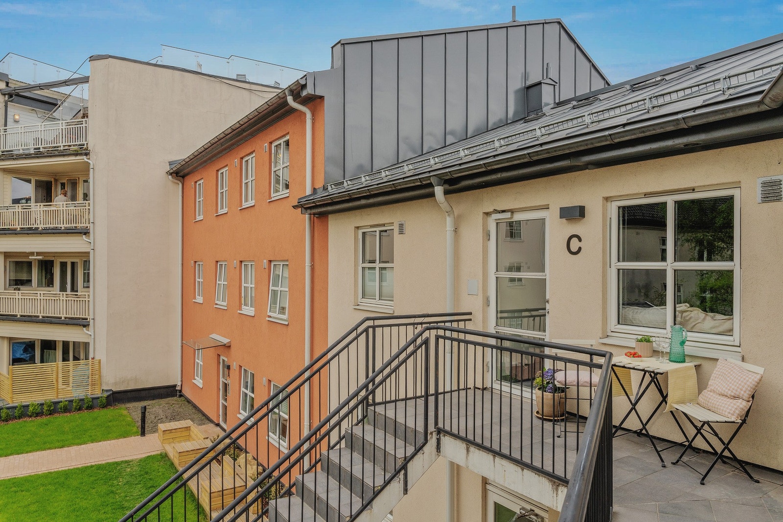 Opp trappen fra bakgården finner vi leiligheten, og rett utenfor er det en stor svalgang / brannbalkong. Galleribilde