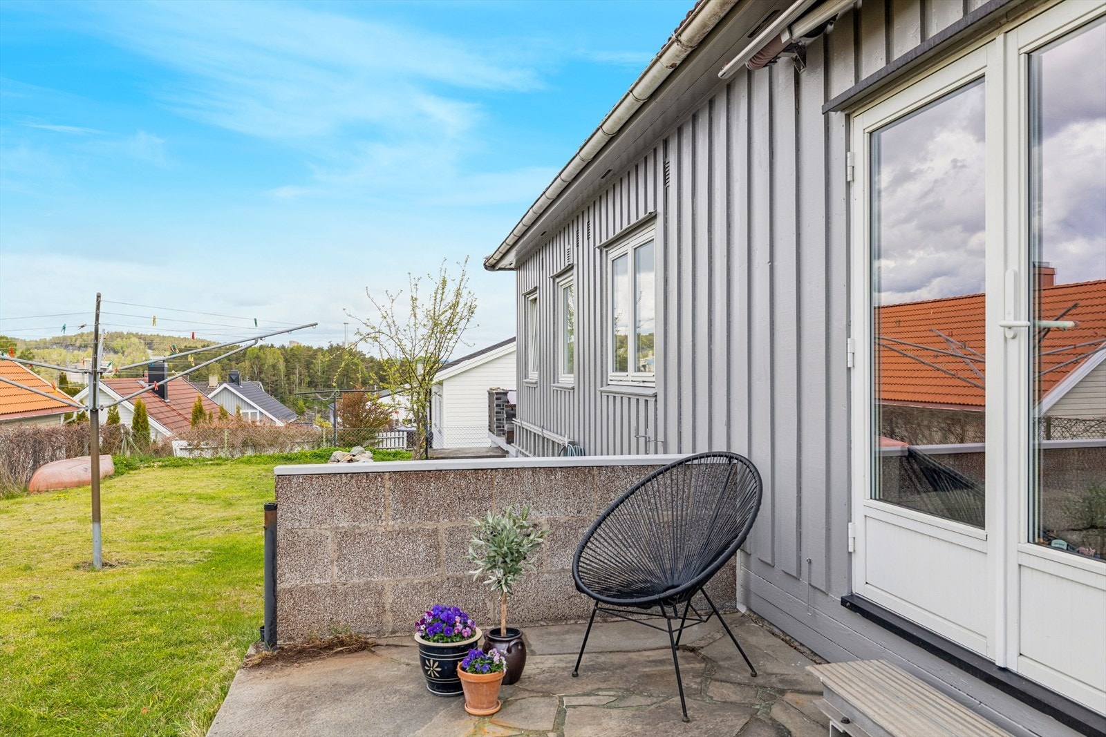 Fra stuen er det utgang til en terrasse med skiferdekke og videre tilgang til hagen. Galleribilde