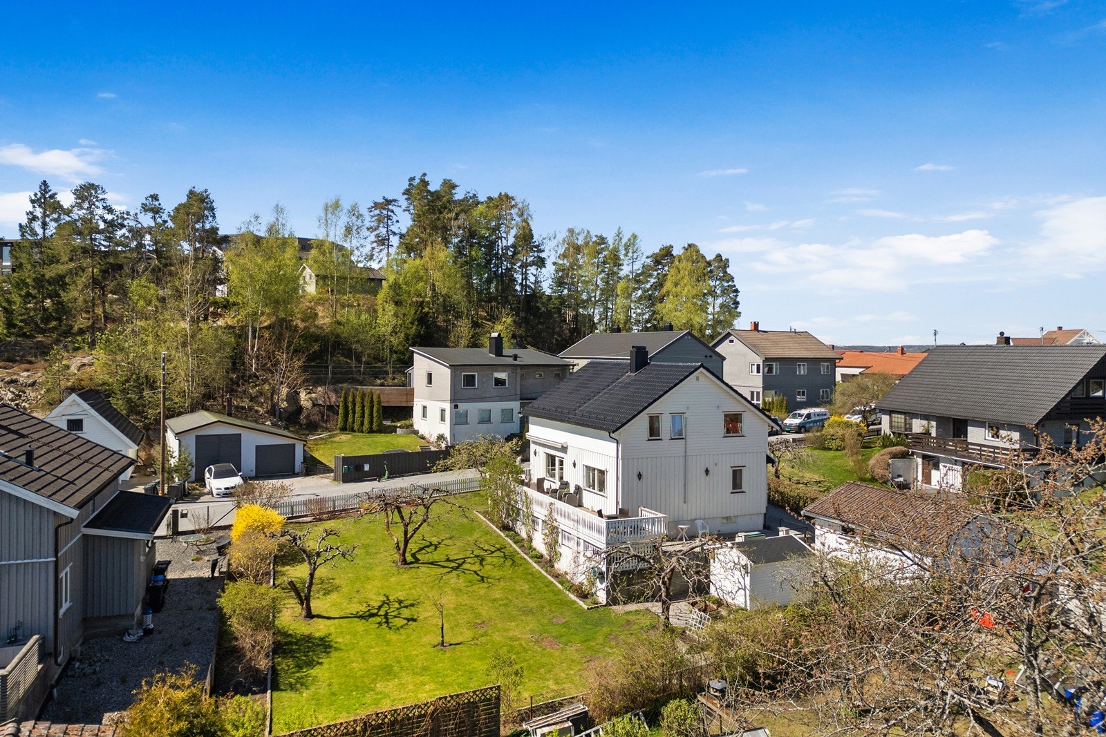 Eiendommen har en skrånende tomt som er opparbeidet med plen og beplantning. Galleribilde
