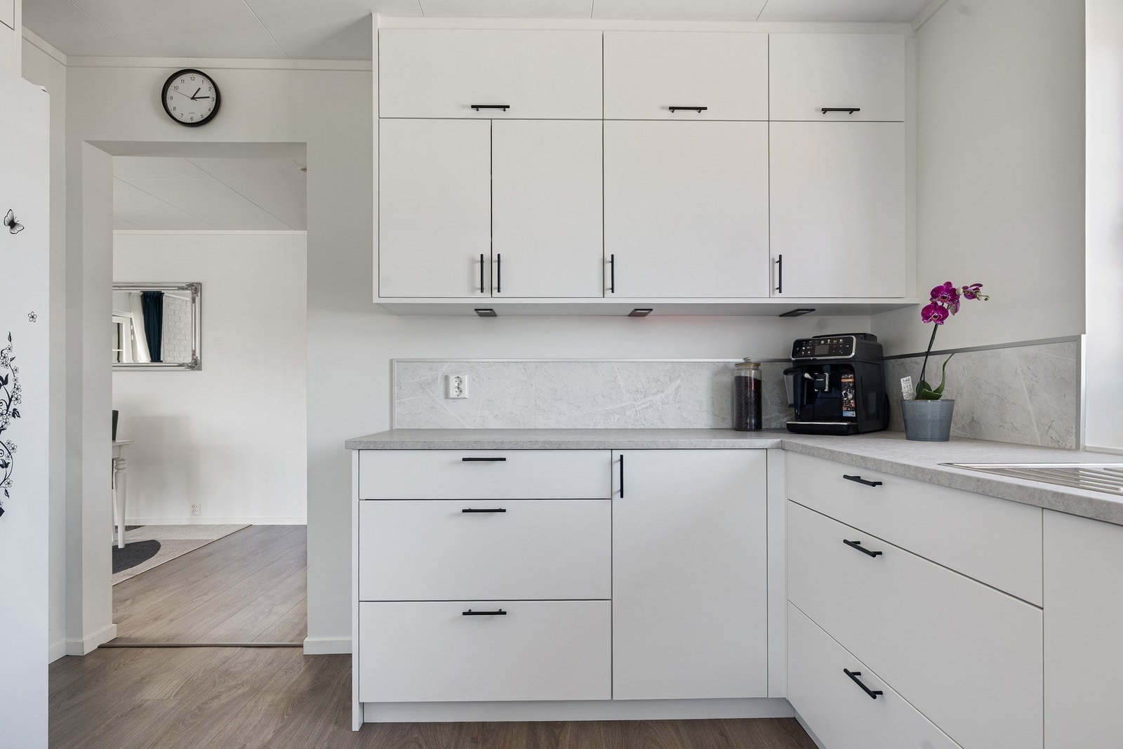 Benkebelysning og downlights bidrar til et moderne og gjennomført uttrykk, mens kjøkkenplatene over benkeplaten gjør overflatene både praktiske og enkle å vedlikeholde. Galleribilde