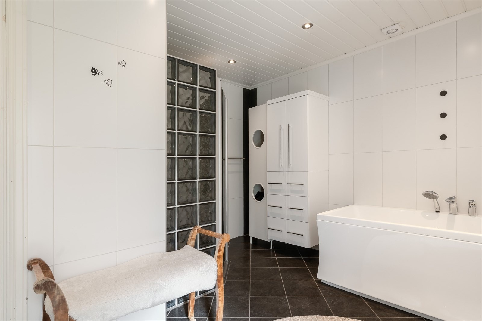 Rommet er innredet med badekar, vegghengt servantinnredning med god skuffeplass, speilskap med belysning og toalett. Galleribilde