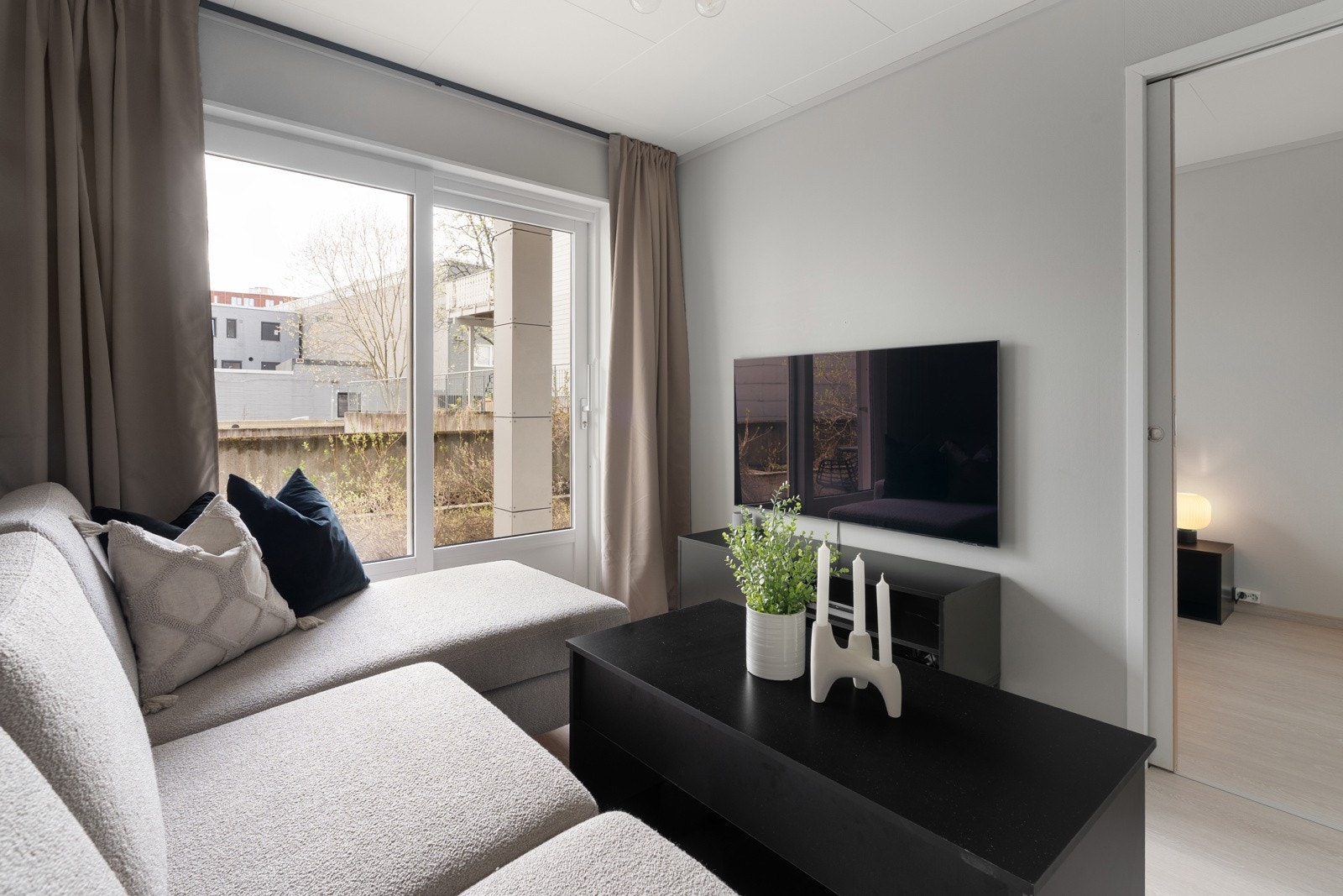 Stuen har vegger malt i moderne farger, nyere gulv og det er skyvedør som leder ut til terrassen Galleribilde