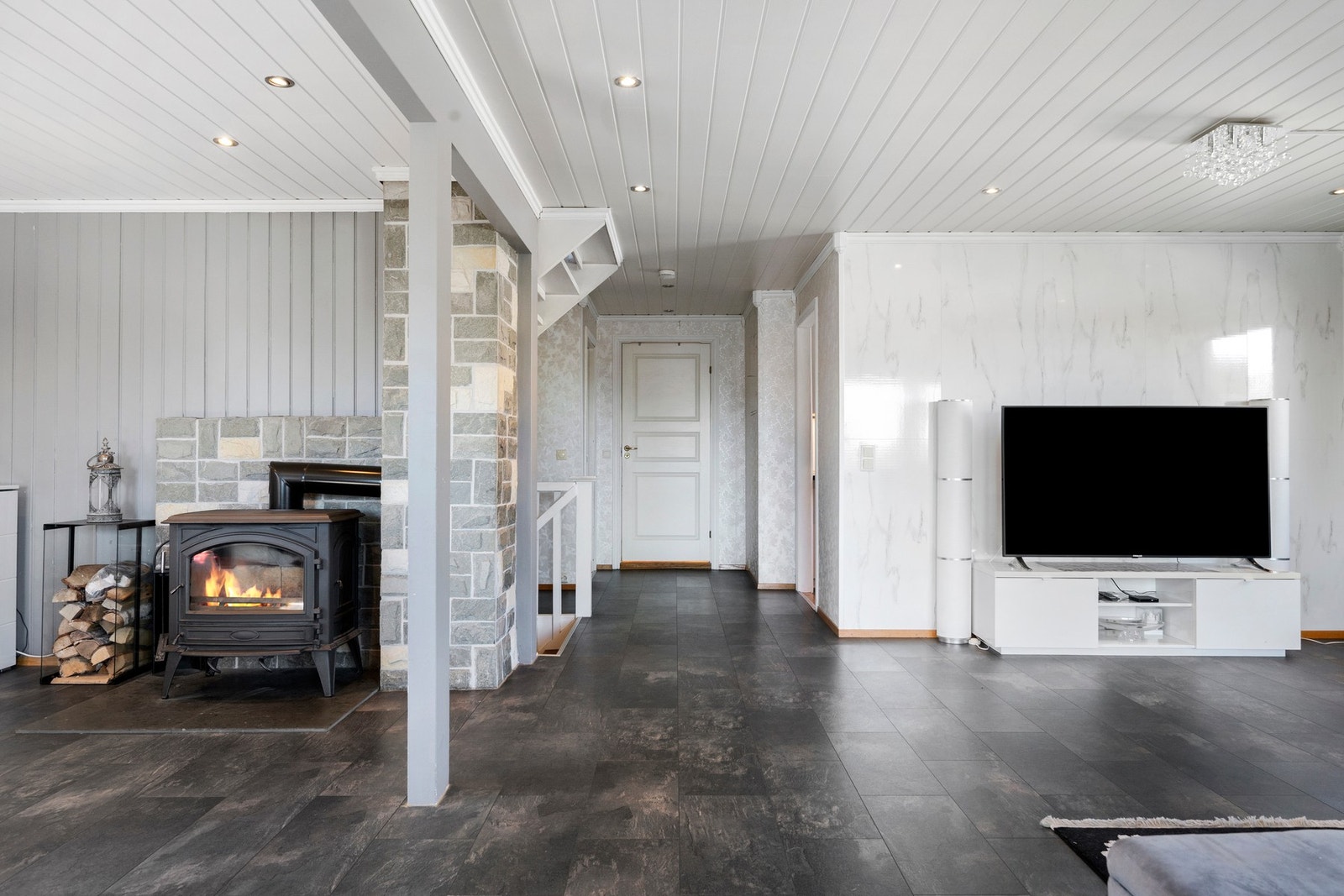 Lys og romslig stue med flere møbleringsmuligheter og peisovn som skaper en hyggelig atmosfære. Galleribilde