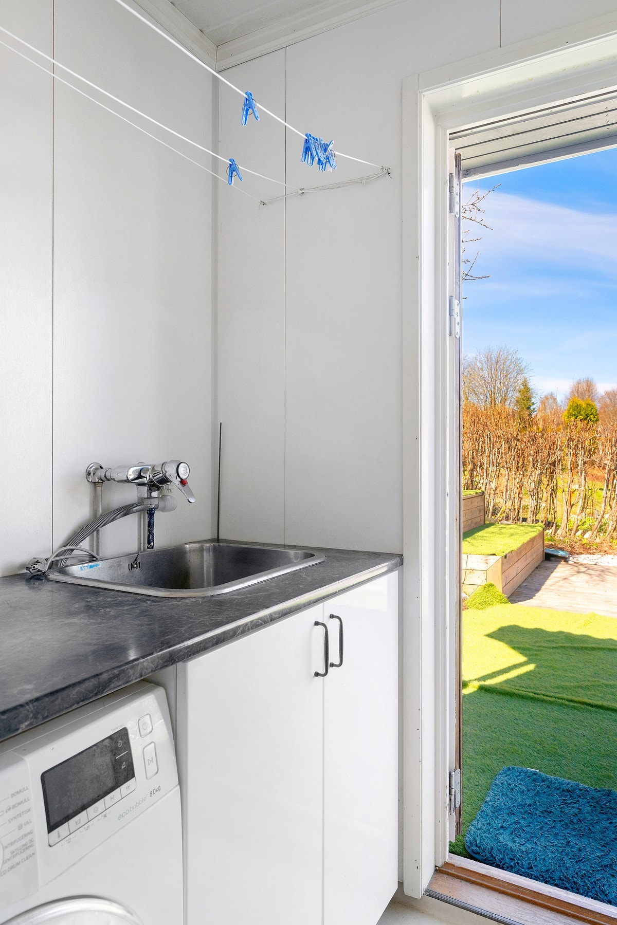 Praktisk vaskerom med egen utgang til terrasse og uteområde. Galleribilde
