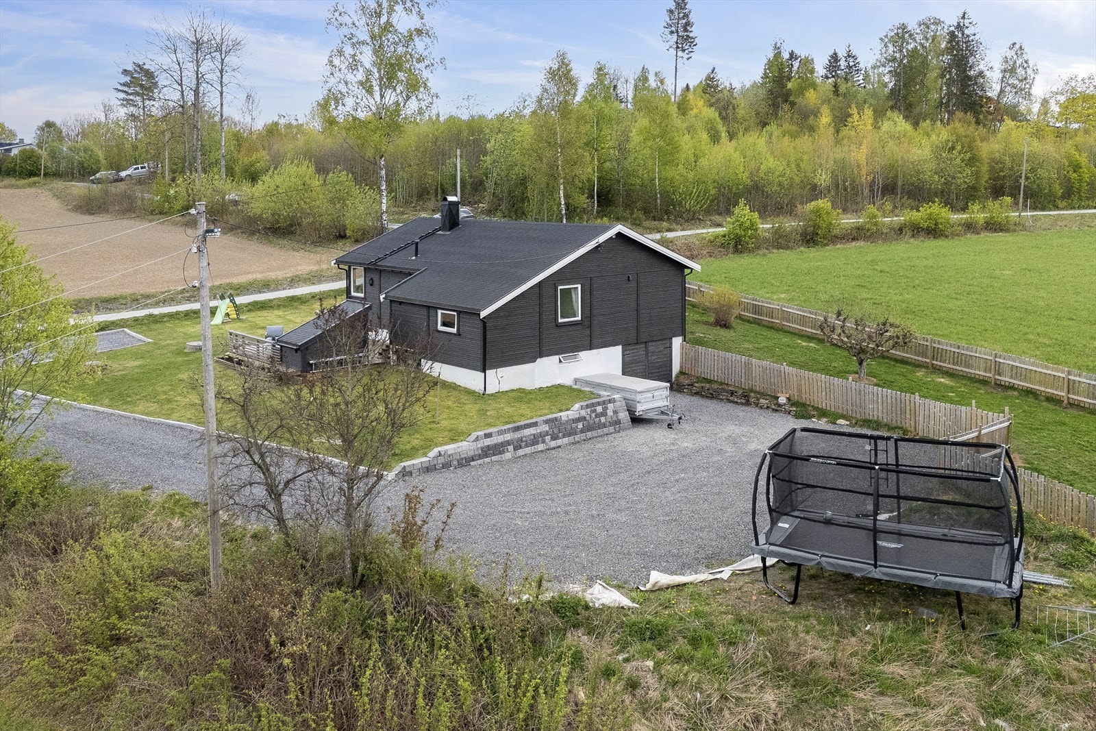 Romslig gårdsplass med plass til barneleker, hengere og biler. Gårdsplassen er påkostet med kantsten, duk under pukken og lagt ny pukk. Galleribilde
