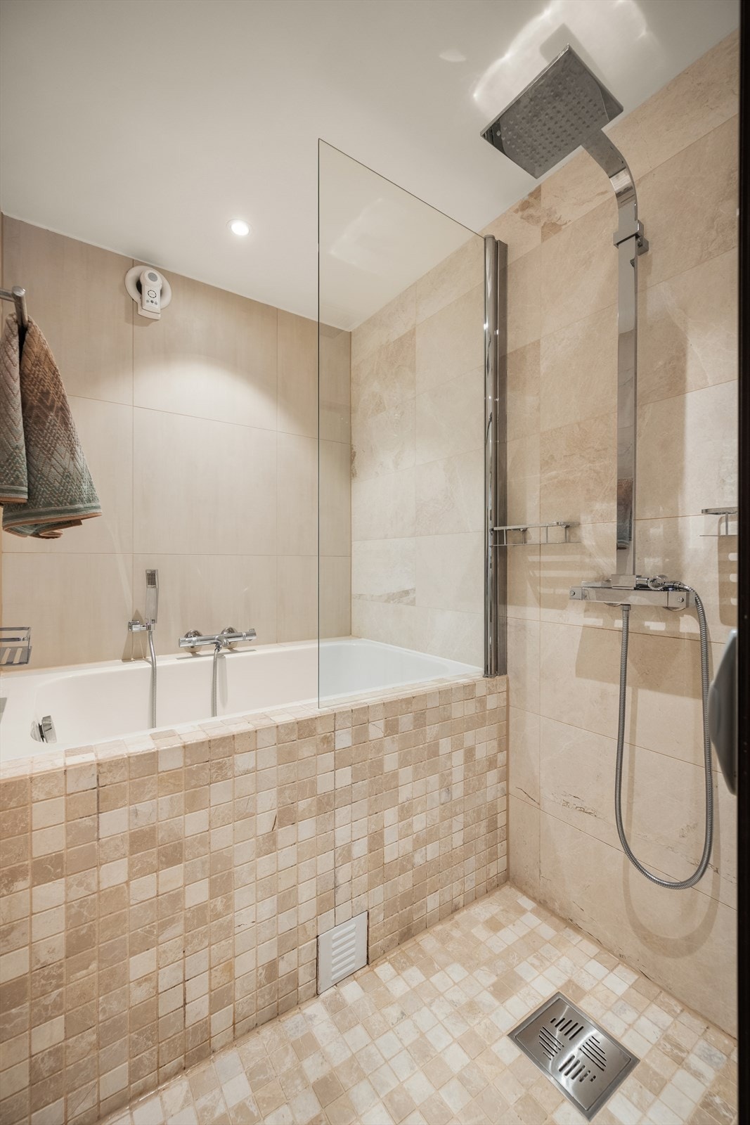 Badet er utstyrt med badekar og dusjhjørne med skyvbare glassdører. Galleribilde