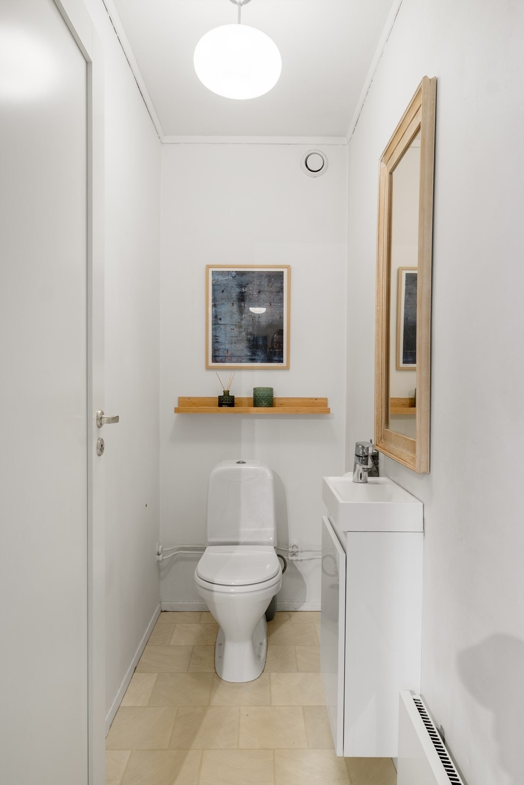 Separat wc med malte vegger, servant med underskap, speil og panelovn. Galleribilde
