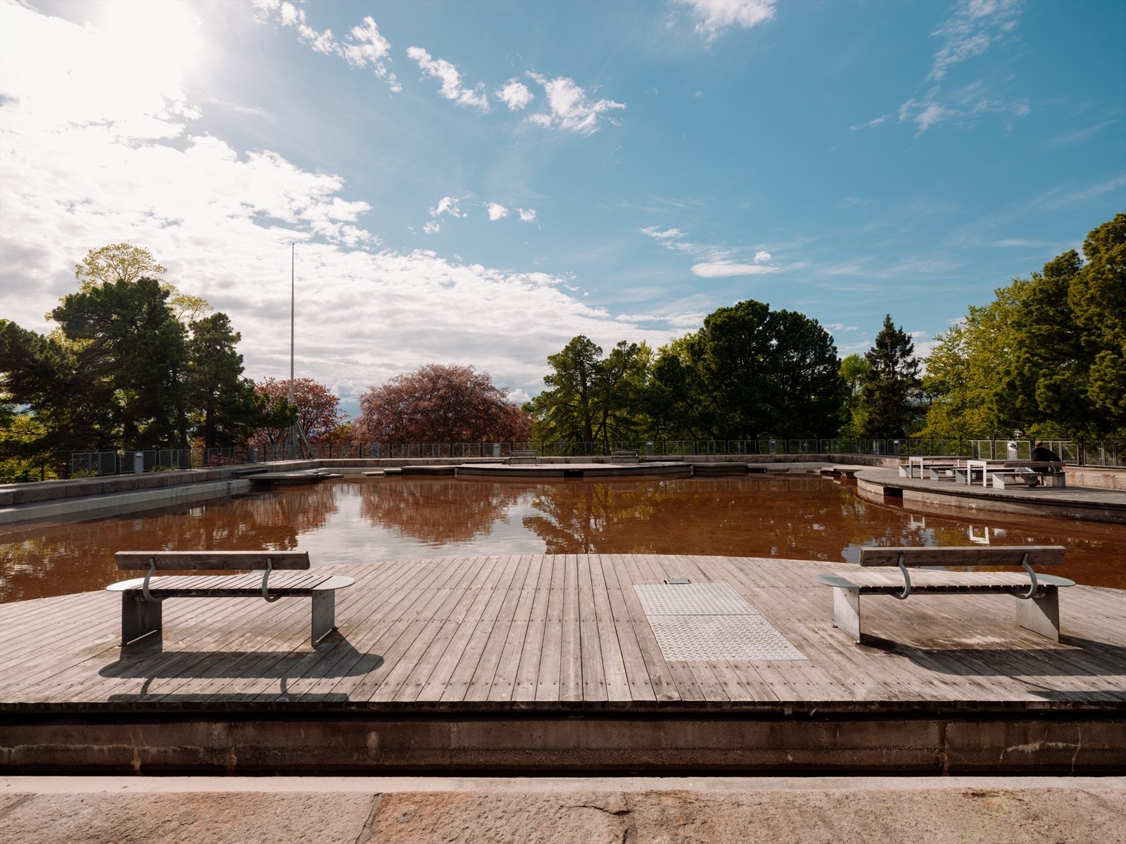 Kampen park byr på store gressplener, sittebenker og et vannspeil. Galleribilde