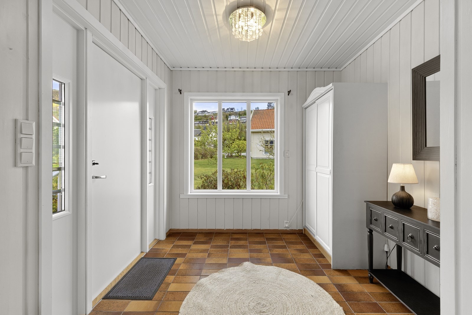 Vidare inn i bustaden kjem ein til eit lyst og innbydande vindfang med flis på golv og gode oppbevaringsmoglegheiter i garderobeskåp. Galleribilde