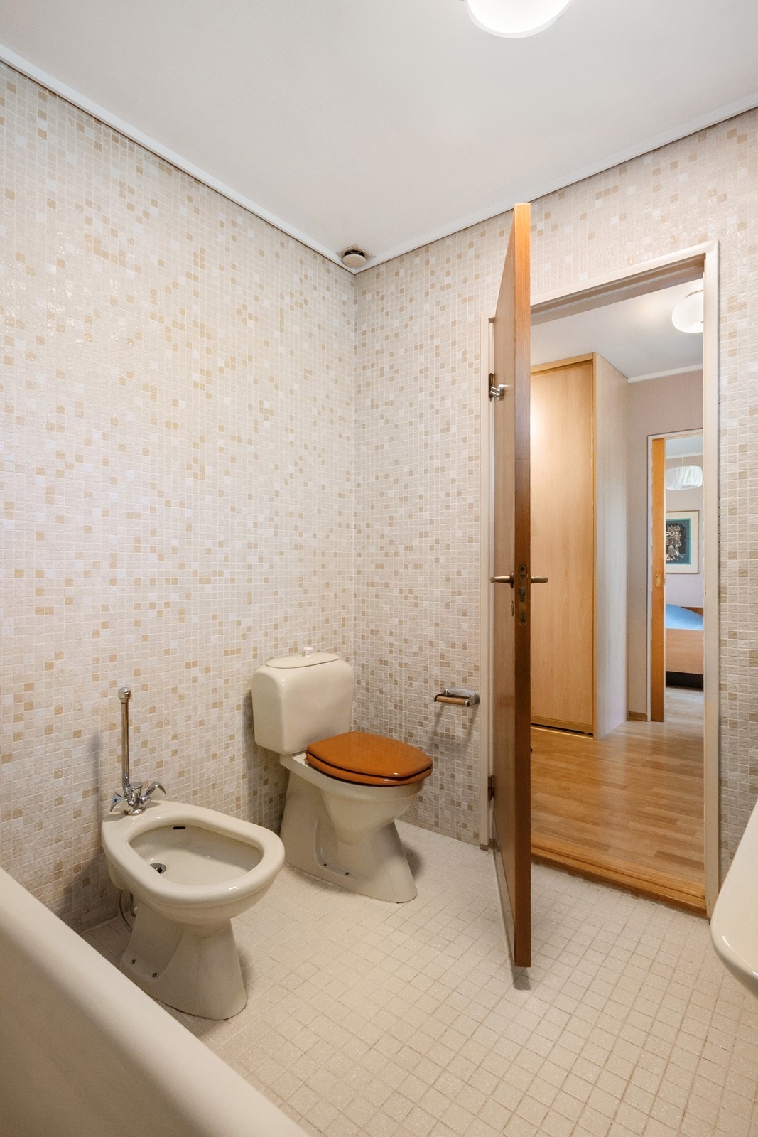 En suite badet er innredet med toalett, bidé, badekar og to enkle servanter. Galleribilde