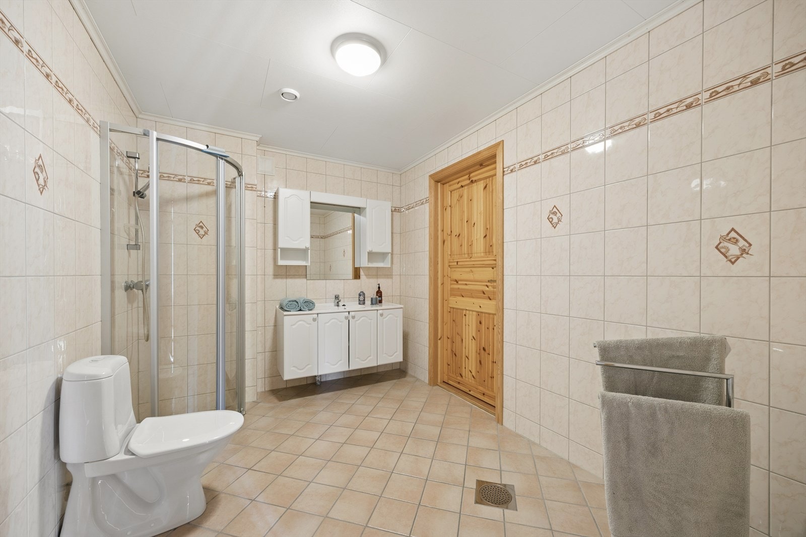 Stort flislagt bad fra byggeår som har varmekabler i gulvet. Fra badet er det adkomst til romslig bod Galleribilde