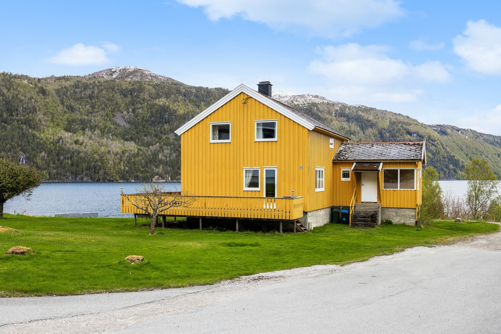 Eiendommen ligger naturskjønt til med utsikt mot fjord og omkringliggende landskap. Galleribilde