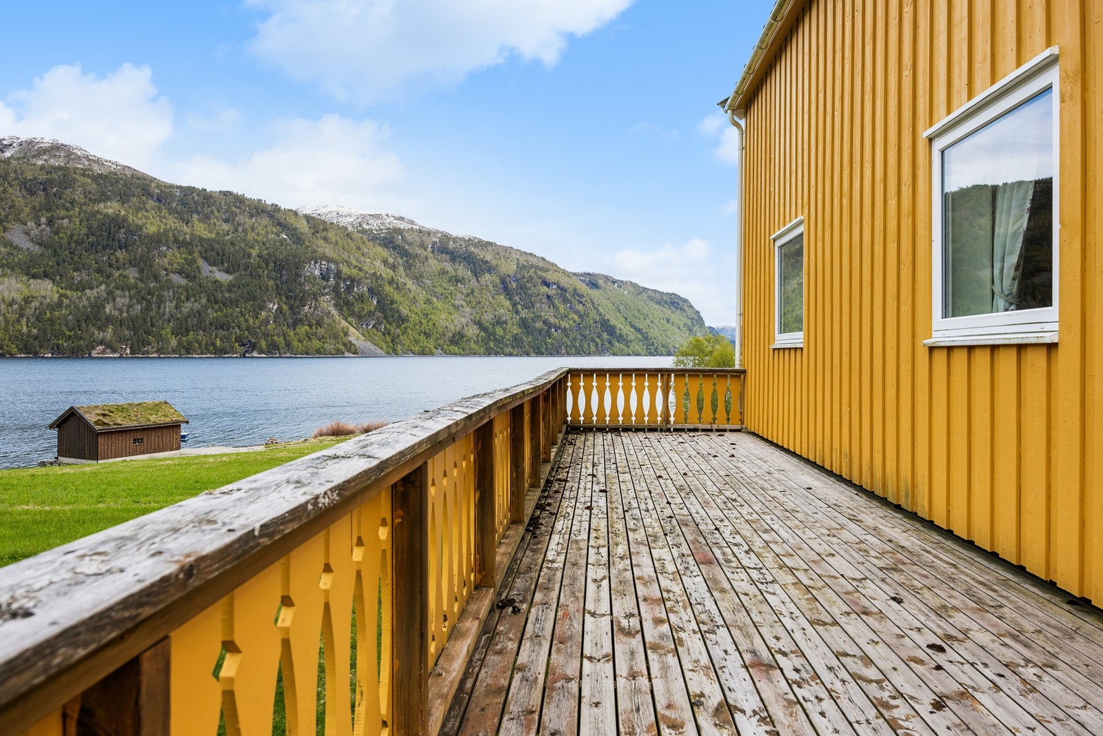 Romslig terrasse med utsikt mot sjø og fjellandskap. Galleribilde