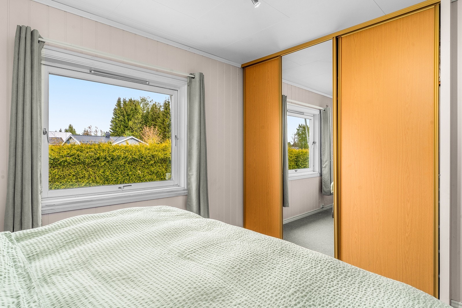 En stor skyvedørsgarderobe med speilfronter gir rikelig med oppbevaringsplass. Galleribilde