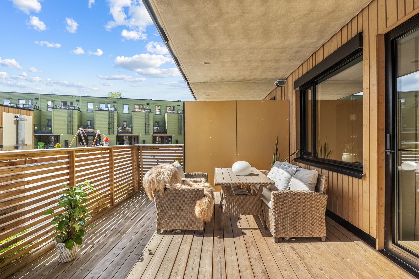 Terrassen er overbygget, har terrassebord på gulv og rekkverk med liggende trespiler. Den gode størrelsen gjør at du enkelt kan innrede med flere ulike sittegrupper etter eget ønske og behov. Galleribilde