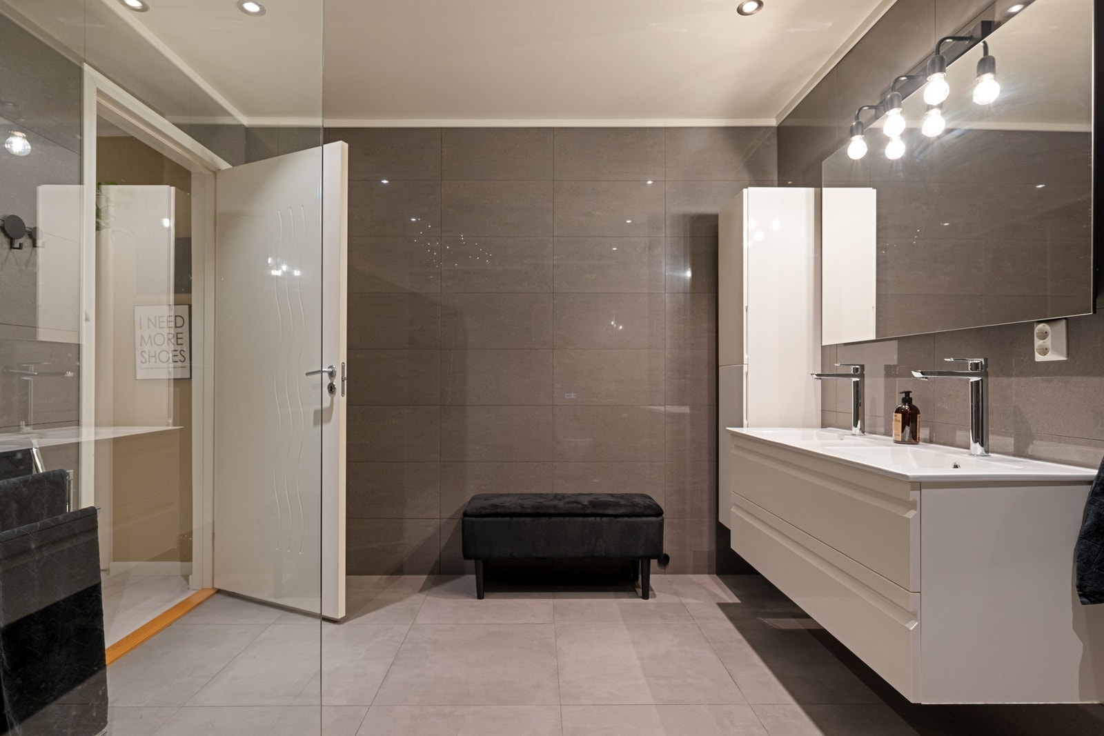 Doble servanter og god plass gjør badet både praktisk og funksjonelt, samtidig som helheten oppleves elegant og innbydende. Galleribilde