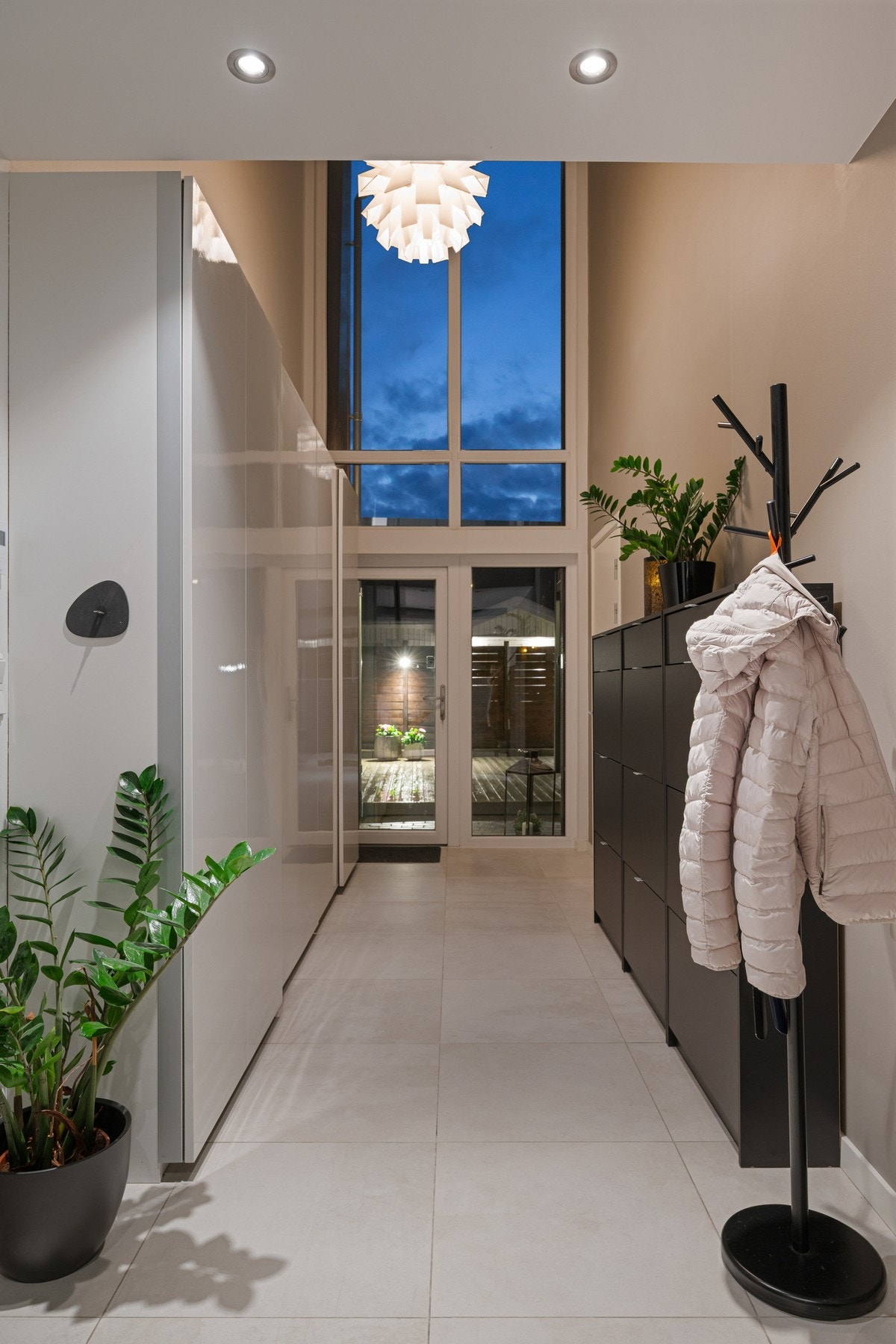 Her kommer du inn i en luftig hall med skyvedørsgarderobe og imponerende takhøyde. Galleribilde
