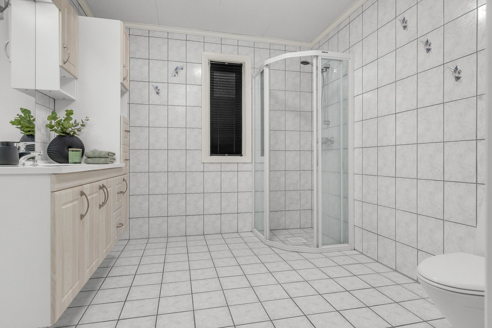 Badet i første etasje er fra byggeåret, med flislagt gulv og vegger. Galleribilde