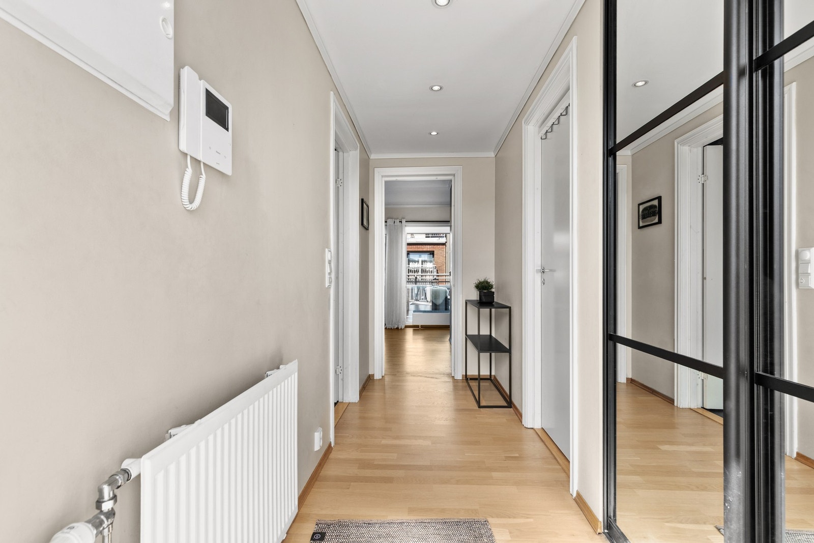 Romslig entré/gang med parkettgulv og slette vegg- og himlingsflater Galleribilde