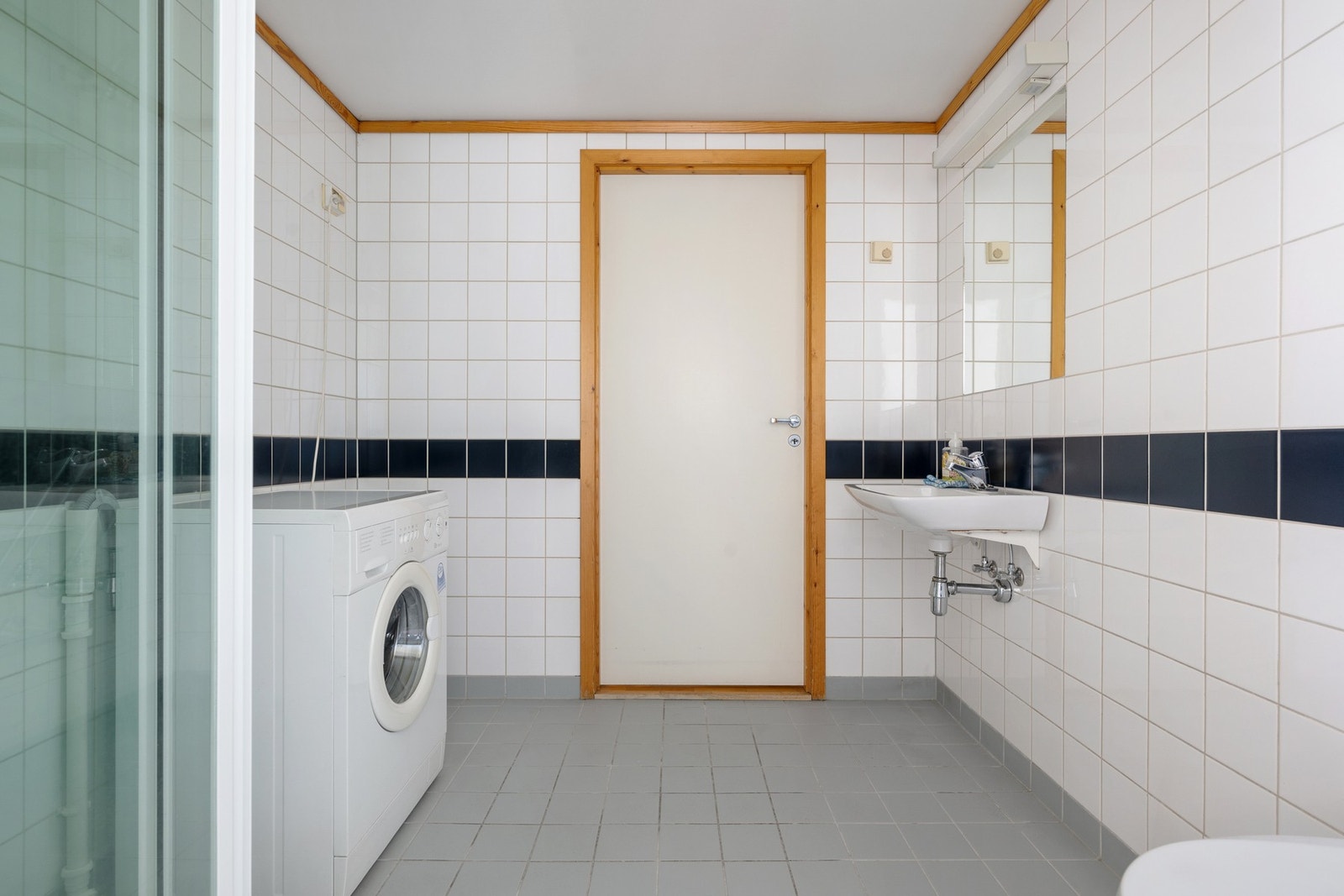 Romslig, flislagt bad med vegghengt toalett og plass til vaskemaskin. Galleribilde