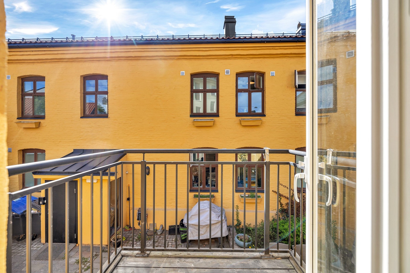 Utgang til flott balkong vendt mot hyggelig felles bakgård Galleribilde