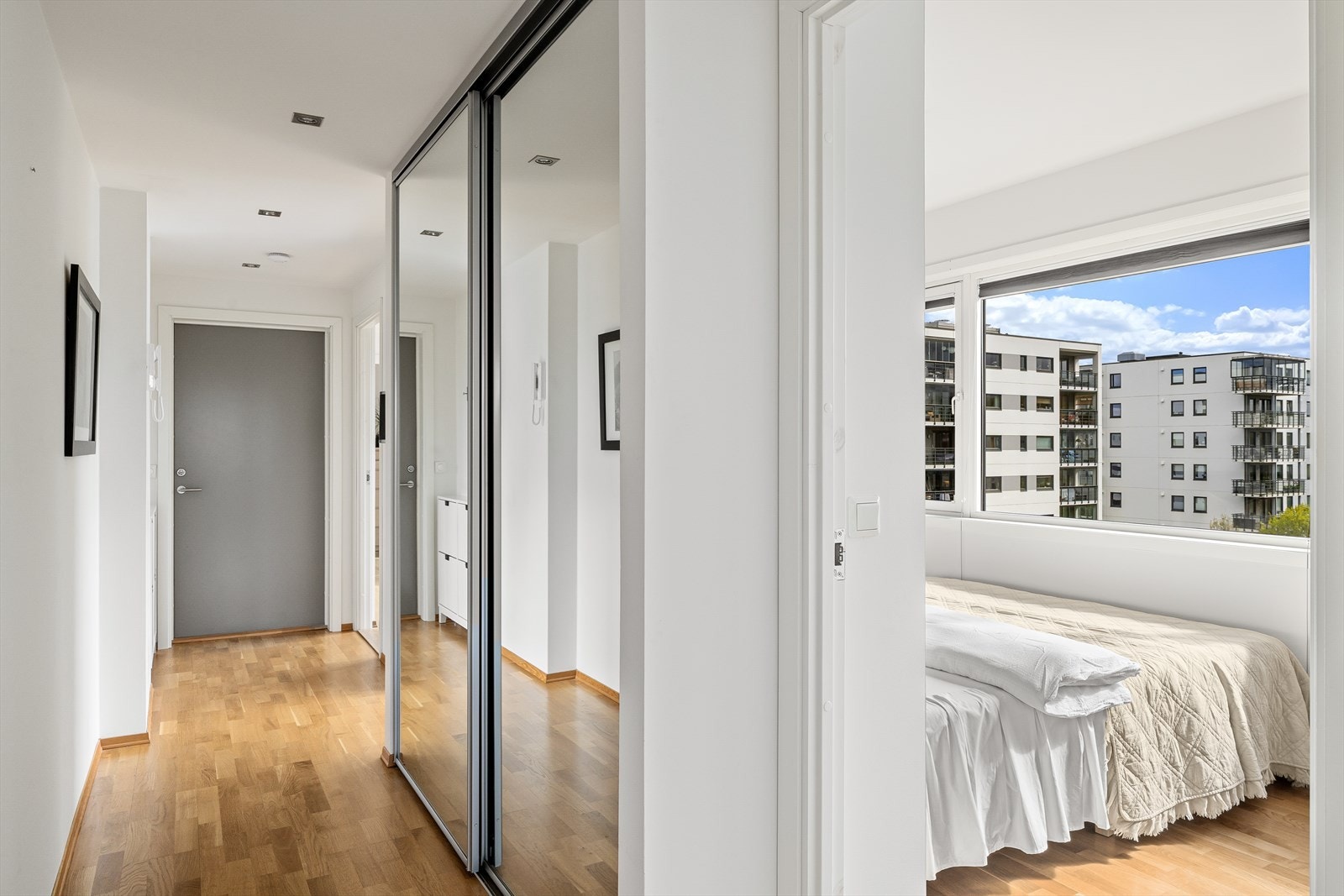 En romslig skyvedørsgarderobe med speilfronter i gangen gir rikelig med oppbevaringsplass. Galleribilde