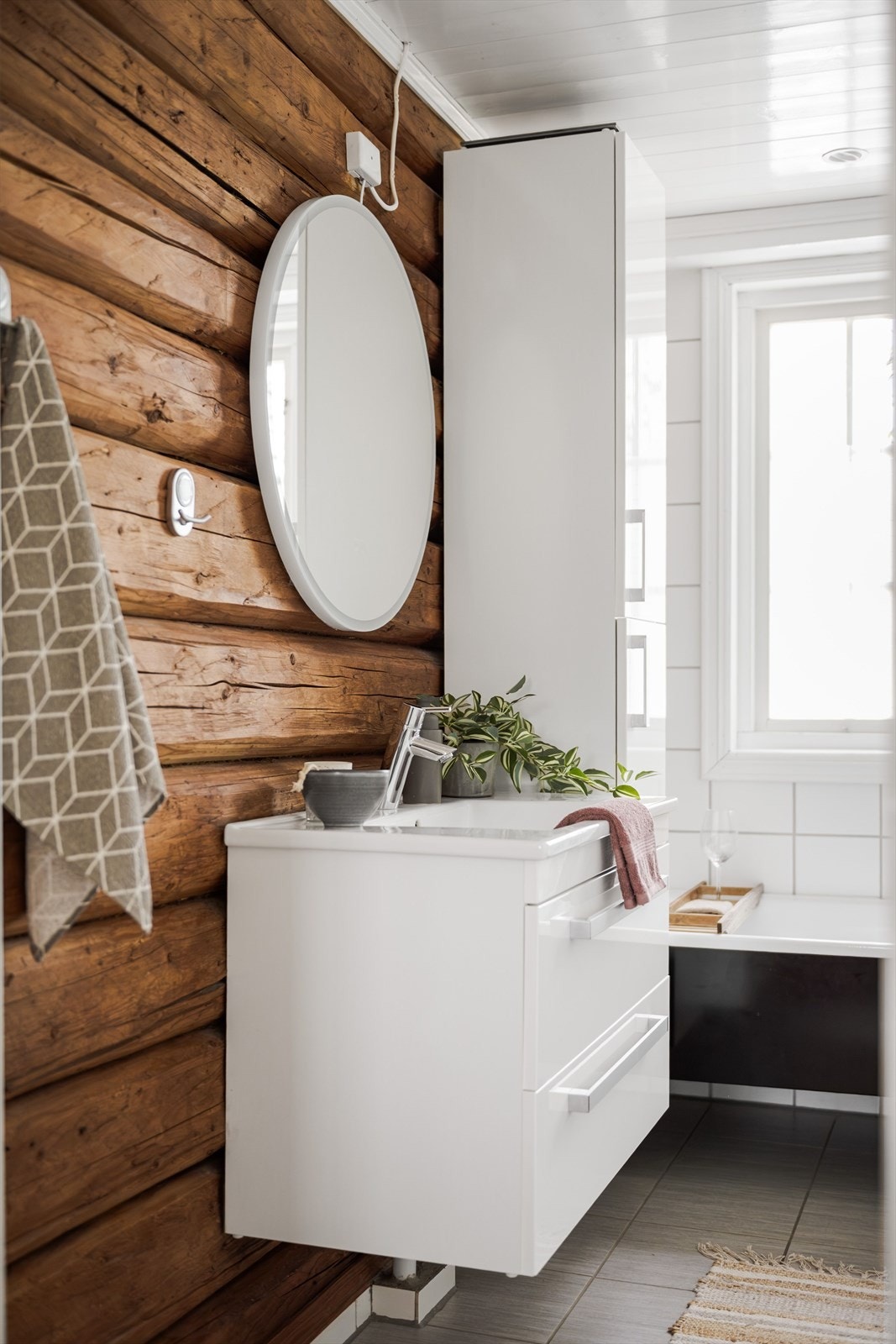 Badet er utstyrt med badekar og lys baderomsinnredning med skuffer og heldekkende servant. Galleribilde