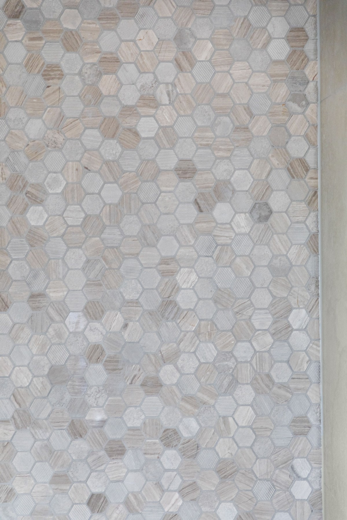 I dusjsonen er det grå mosaikkfliser, og resten av badet har grå, store veggfliser og matchende fliser på gulv med gulvvarme. Galleribilde